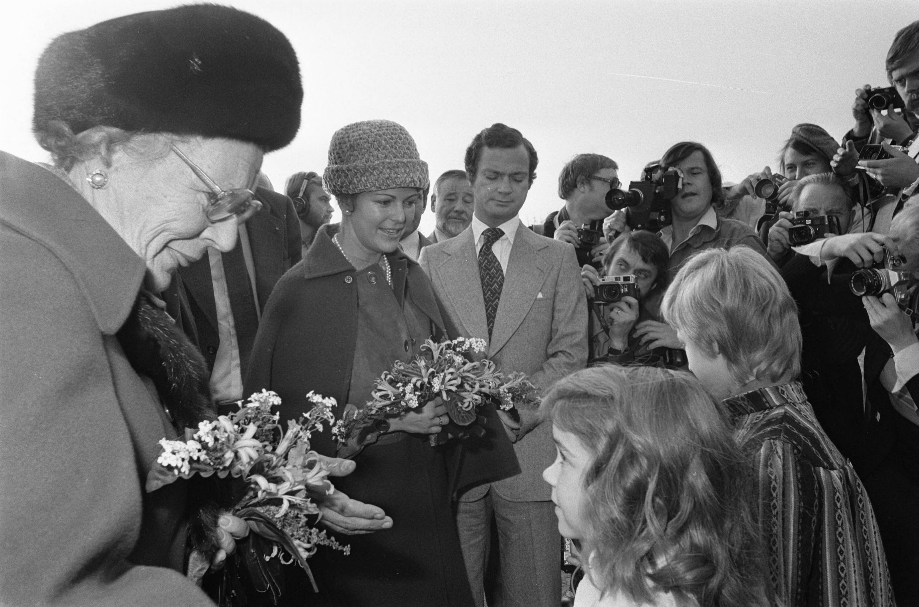 Fotocollectie Anefo — Staatsbezoek Zweeds Kon. Paar aan Nederland; voor Almere informatiekantoor bij Hollandse Brug . HM krijgt bloemen, achter Gustav en Silvia — Foto: Peters, Hans / Anefo. Licentie: Set B: Rechtenvrij / Publiek Domein. Bron: Nationaal Archief. http://hdl.handle.net/10648/ac8e8afa-d0b4-102d-bcf8-003048976d84