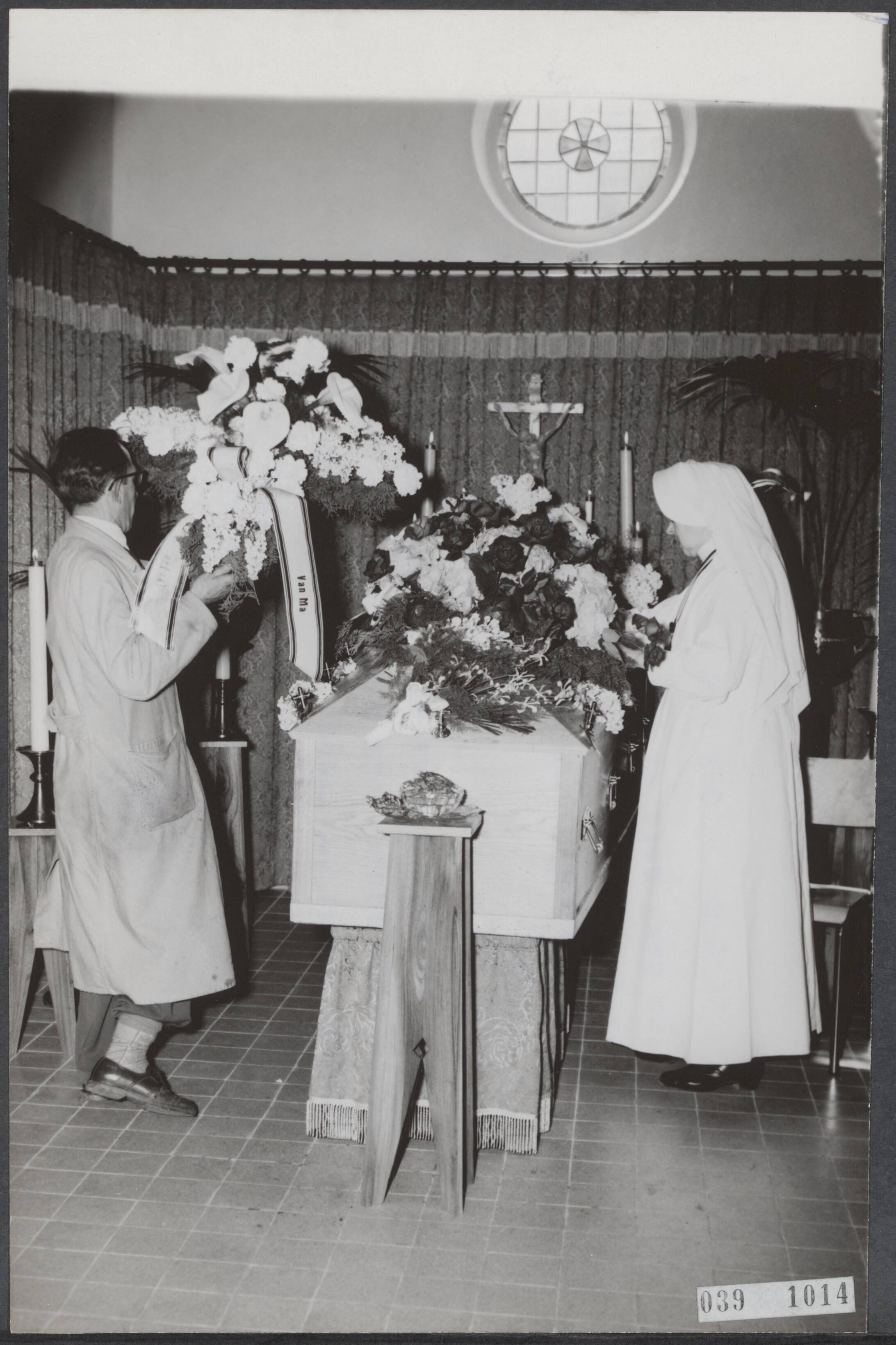 Fotocollectie Elsevier Binnenland — Spionagezaak Jungschlaeger (Indonesië). Het stoffelijk overschot van Jungschlaeger is van dinsdagmiddag 2 uur tot de plechtige uitvaart op woensdagmorgen opgebaard in de Chapelle ardente van het voormalig ziekenhuis "Calvarienberg" in Maastricht. Een bloemstuk wordt hier afgeleverd afkomstig van de moeder van Jungschlaeger. Op het lint is duidelijk het opschrift "van Ma" te zien — Foto: Fotograaf Onbekend / Anefo. Licentie: Set B: Rechtenvrij / Publiek Domein. Bron: Nationaal Archief. http://hdl.handle.net/10648/adf3bc4e-d0b4-102d-bcf8-003048976d84