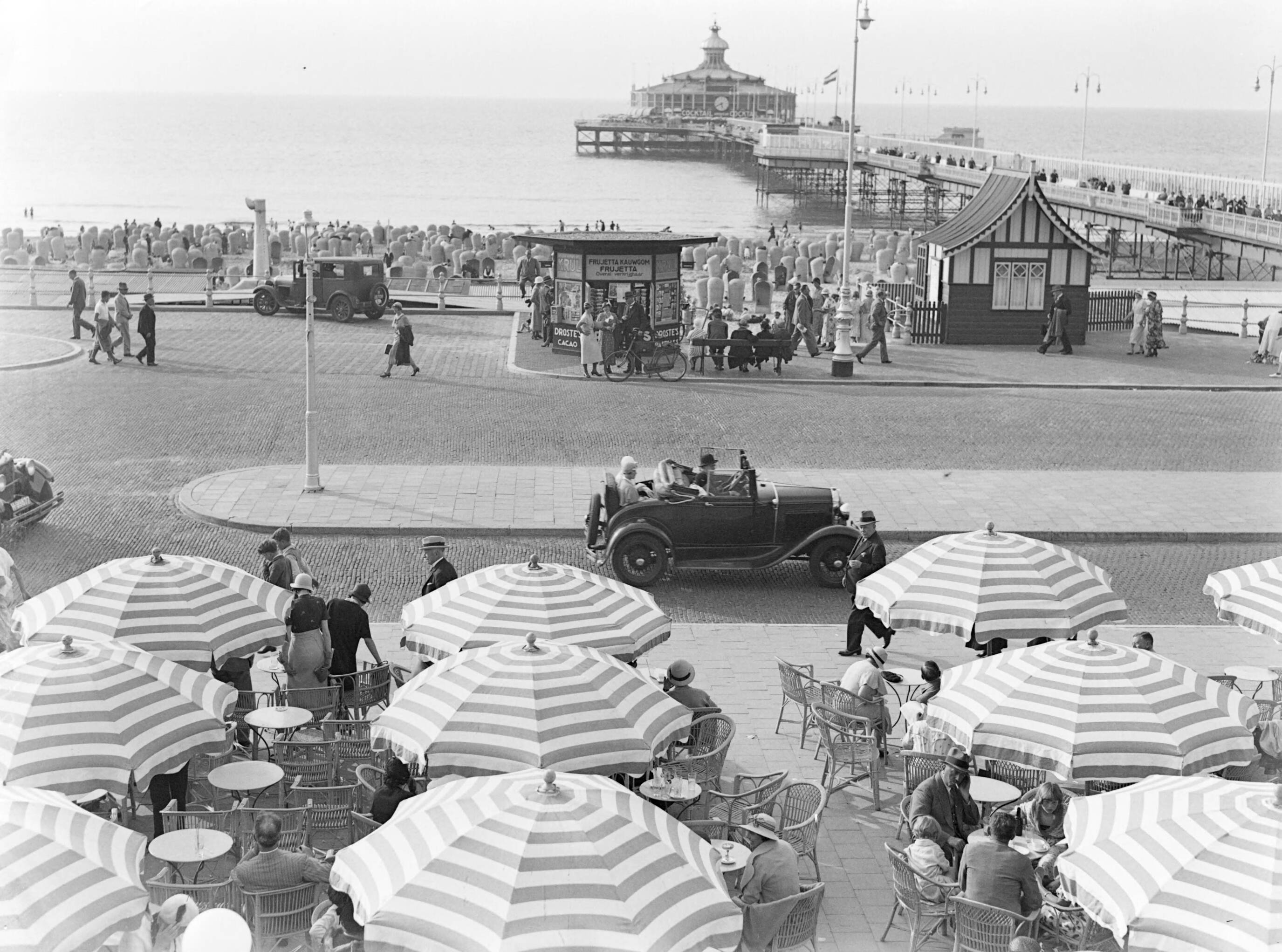 Scheveningen. — Uitzicht op een terras op de boulevard in Scheveningen — Foto: Poll, Willem van de. Licentie: Set B: Rechtenvrij / Publiek Domein. Bron: Nationaal Archief. http://hdl.handle.net/10648/ae9acd86-d0b4-102d-bcf8-003048976d84