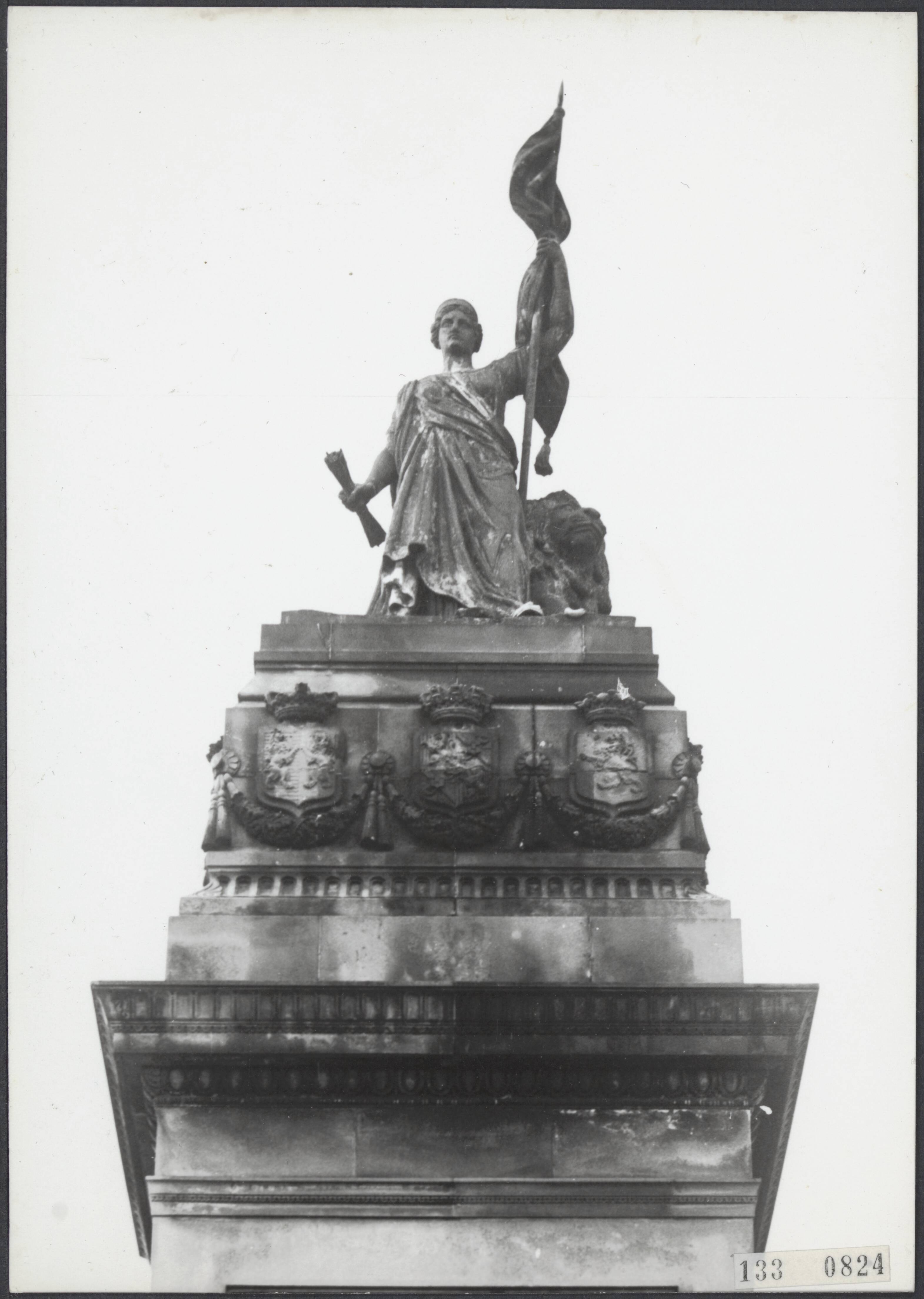 Fotocollectie Rijksvoorlichtingsdienst Eigen — Den Haag. Plein 1813: de Nederlandse Maagd met leeuw en vlag als bekroning van het monument voor 50 jaar Nederlandse Onafhankelijkheid (1869) naar plannen van J. Ph. Koelman (sculptuur) en W.C. van der Waeyen Pieterszen (architectuur) — Foto: Fotodienst Gemeente Den Haag. Licentie: Set B: Rechtenvrij / Publiek Domein. Bron: Nationaal Archief. http://hdl.handle.net/10648/af5aa66a-d0b4-102d-bcf8-003048976d84