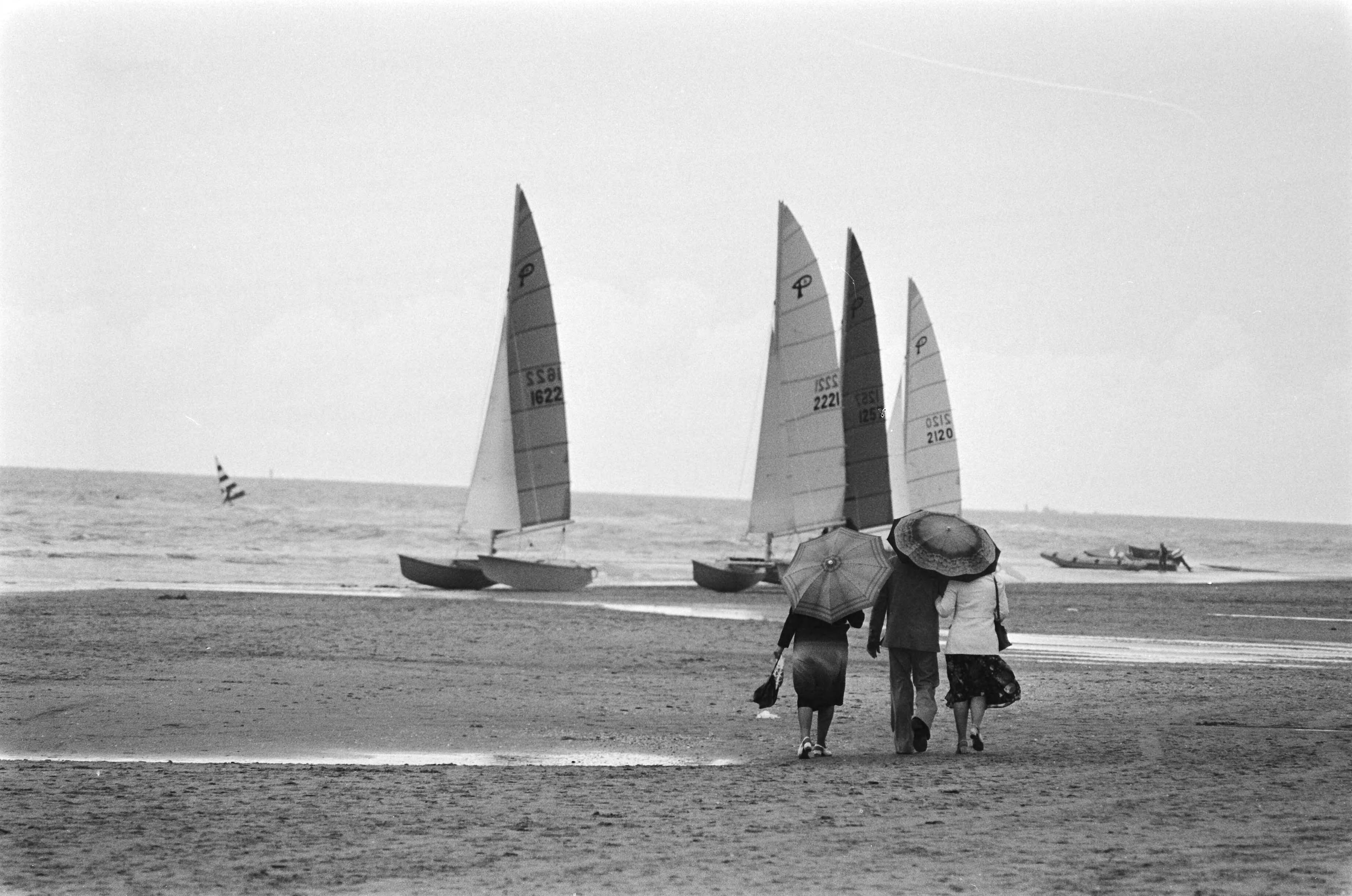 Fotocollectie Anefo — Verlaten strand Zandvoort met wandelaars met paraplus in regen — Foto: Peters, Hans / Anefo. Licentie: Set B: Rechtenvrij / Publiek Domein. Bron: Nationaal Archief. http://hdl.handle.net/10648/acb9a55a-d0b4-102d-bcf8-003048976d84