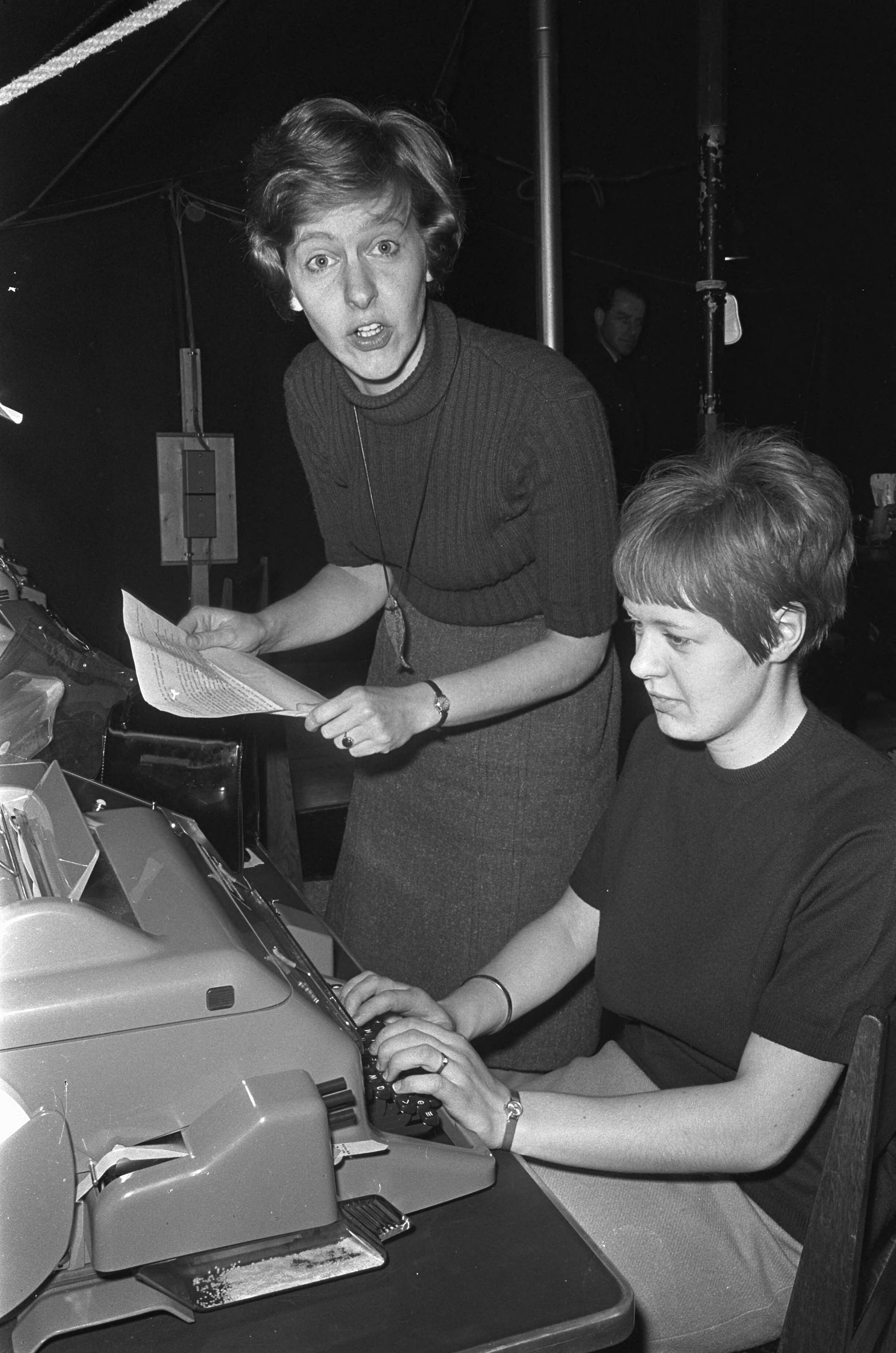Fotocollectie Anefo — In het perscentrum in Lage Vuursche komt elke dag ANP-verslaggeefster Elly boer haar berichten doorgeven aan de dames van de PTT die de telex bedienen en op die manier zorgen dat het nieuws van Drakenstein wereldkundig wordt gemaakt. Als straks de baby geboren is zal zij hier ook staan om dan die mededeling door te geven, waarna de hele wereld het zal weten. — Foto: Koch, Eric / Anefo. Licentie: Set B: Rechtenvrij / Publiek Domein. Bron: Nationaal Archief. http://hdl.handle.net/10648/ab1530de-d0b4-102d-bcf8-003048976d84