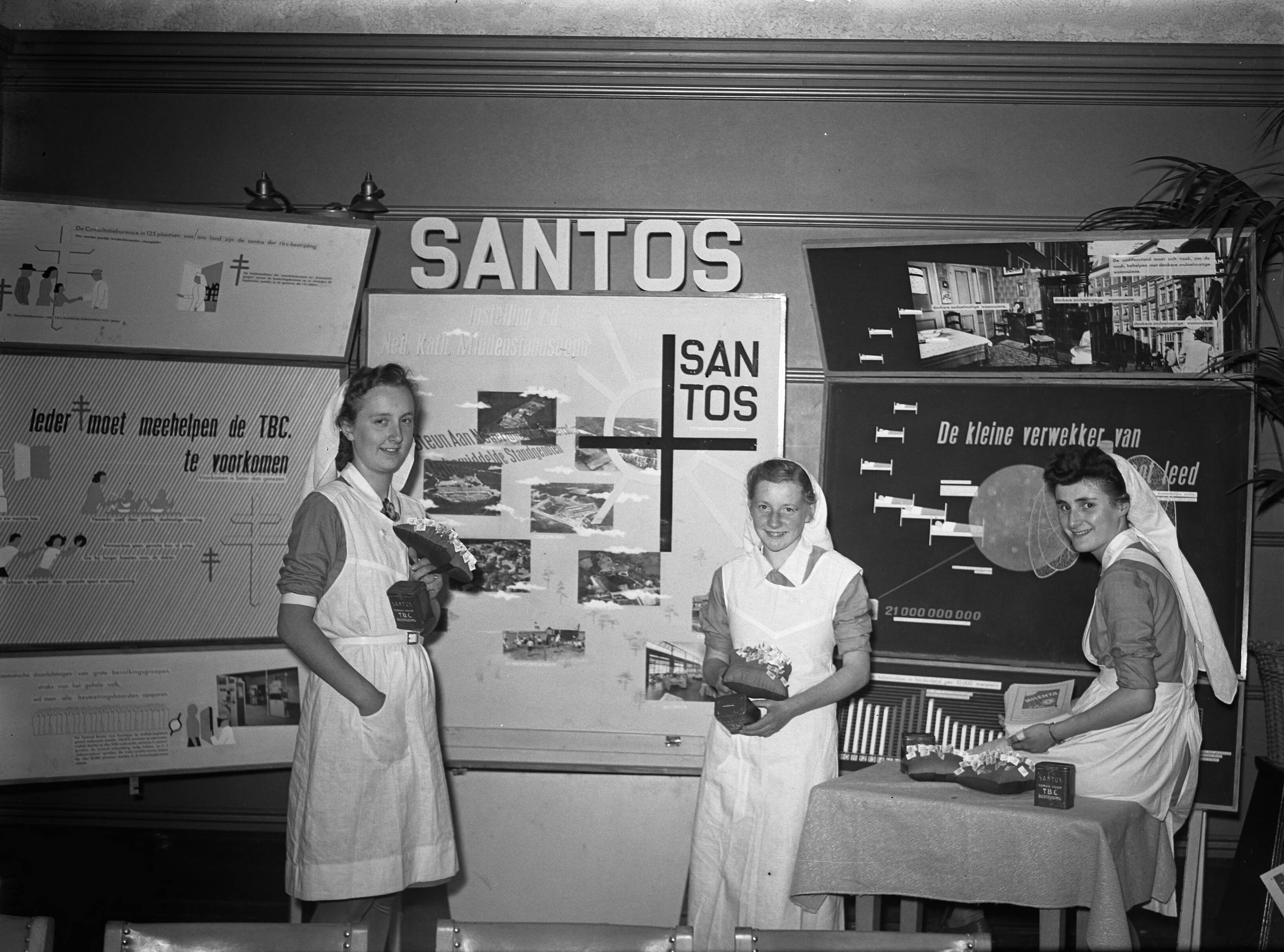Fotocollectie Anefo — Tentoonstelling "Milenta" te Hilversum. Stand van "Santos" met verpleegsters — Foto: Oorschot, […] van / Anefo. Licentie: Set B: Rechtenvrij / Publiek Domein. Bron: Nationaal Archief. http://hdl.handle.net/10648/a8b7545c-d0b4-102d-bcf8-003048976d84