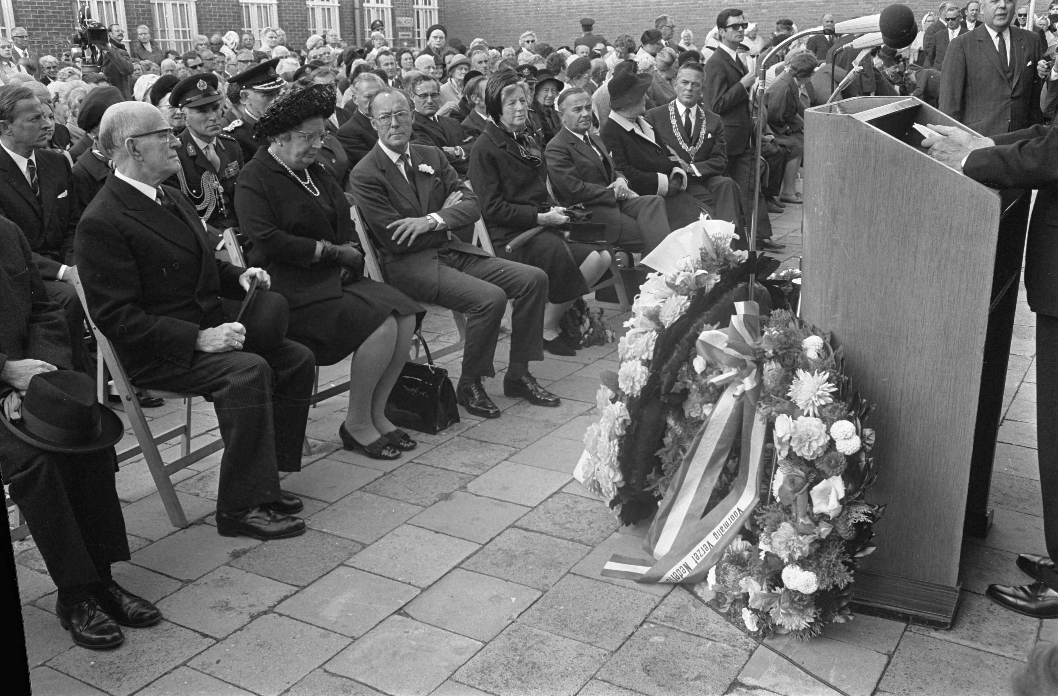 Fotocollectie Anefo — koningin Juliana en Prins Bernhard bij 25e Dodenherdenking in Scheveningse gevangenis bij Cel 601 ; na kranslegging — Foto: Koch, Eric / Anefo. Licentie: Set B: Rechtenvrij / Publiek Domein. Bron: Nationaal Archief. http://hdl.handle.net/10648/aba30e04-d0b4-102d-bcf8-003048976d84