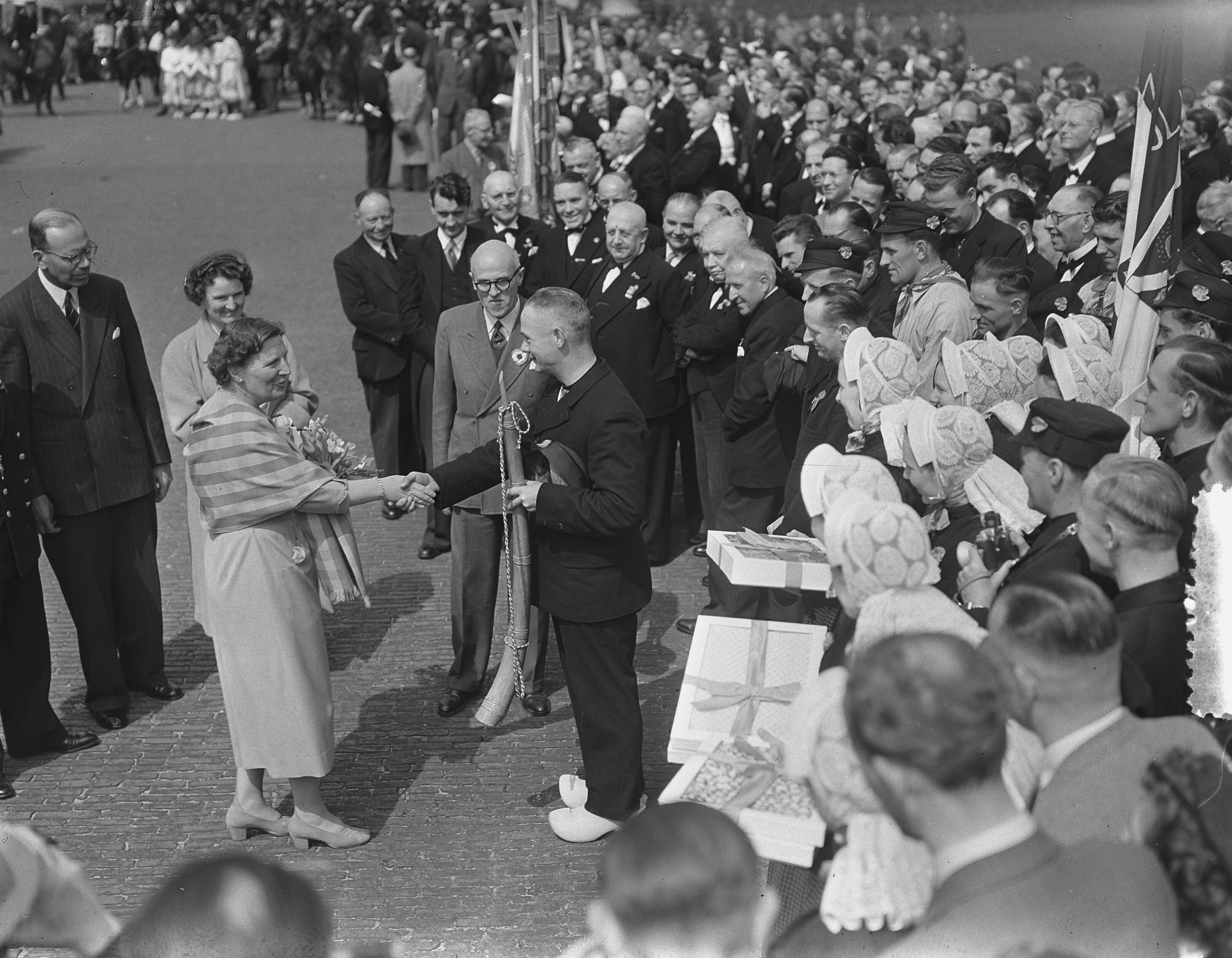 Koninginnedag 1954 — Koninginnedag. Defilé op paleis Soestdijk. Aanbieden geschenk — Foto: Bilsen, Joop van / Anefo. Licentie: Set B: Rechtenvrij / Publiek Domein. Bron: Nationaal Archief. http://hdl.handle.net/10648/a9213b60-d0b4-102d-bcf8-003048976d84