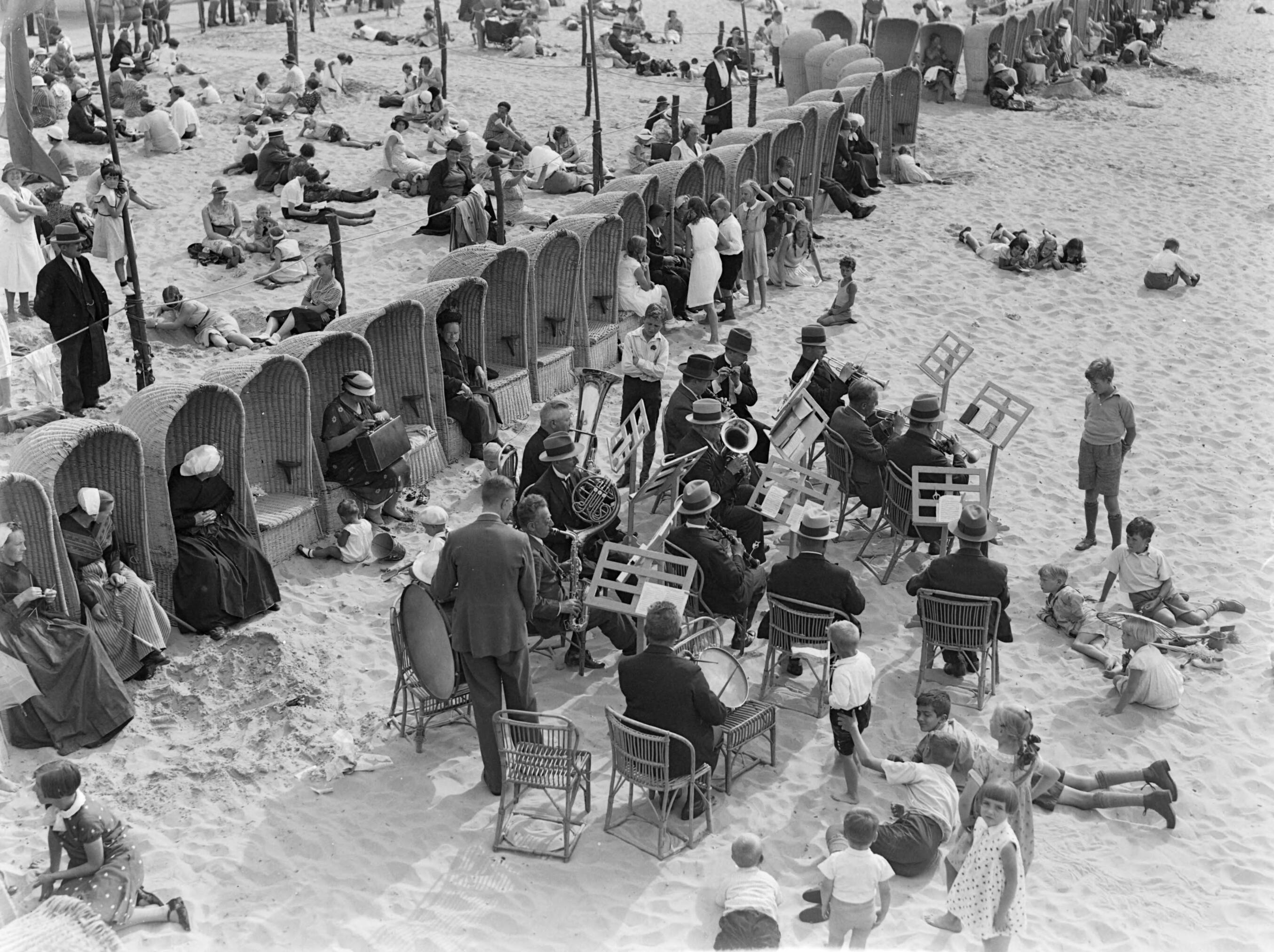 Scheveningen. — Orkest op het strand in Scheveningen — Foto: Poll, Willem van de. Licentie: Set B: Rechtenvrij / Publiek Domein. Bron: Nationaal Archief. http://hdl.handle.net/10648/ae9ac066-d0b4-102d-bcf8-003048976d84