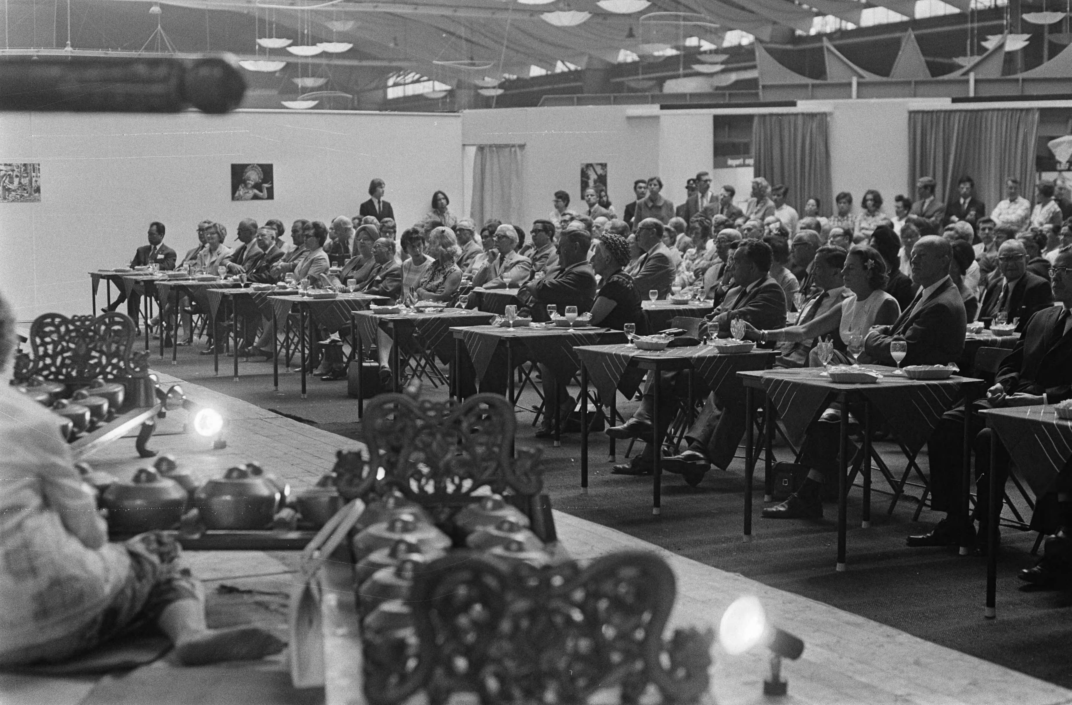 11e Pasar Malam te Den Haag — Een kijkje in de zaal — Foto: Fotograaf Onbekend / Anefo. Licentie: Set B: Rechtenvrij / Publiek Domein. Bron: Nationaal Archief. http://hdl.handle.net/10648/ab700edc-d0b4-102d-bcf8-003048976d84
