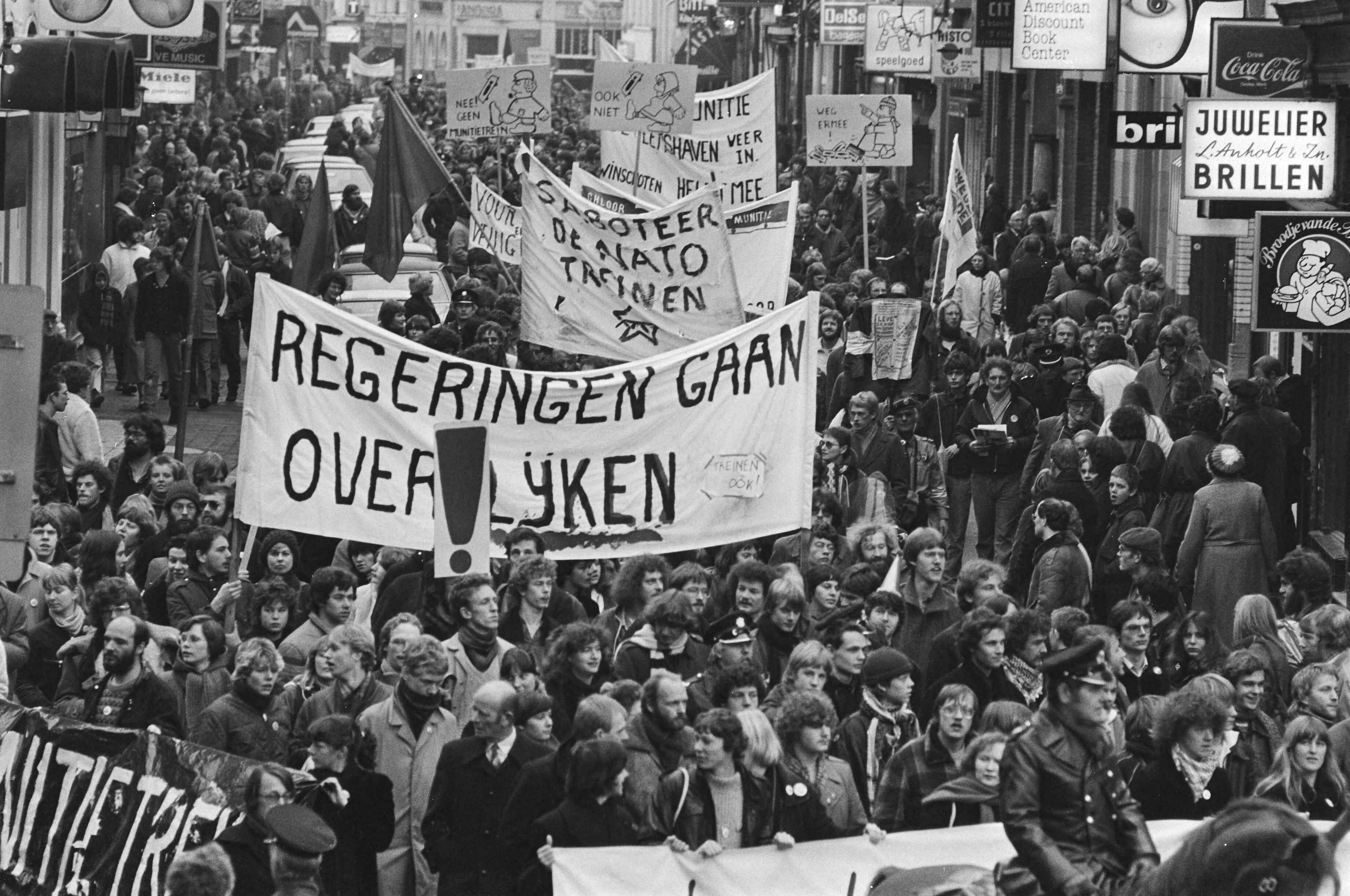 Fotocollectie Anefo — Dem. in Groningen tegen munitietransporten met treinen van de Eemshaven naar West-Duitsland. Dem. met diverse spandoeken — Foto: Bogaerts, Rob / Anefo. Licentie: Set B: Rechtenvrij / Publiek Domein. Bron: Nationaal Archief. http://hdl.handle.net/10648/ad0df7fe-d0b4-102d-bcf8-003048976d84