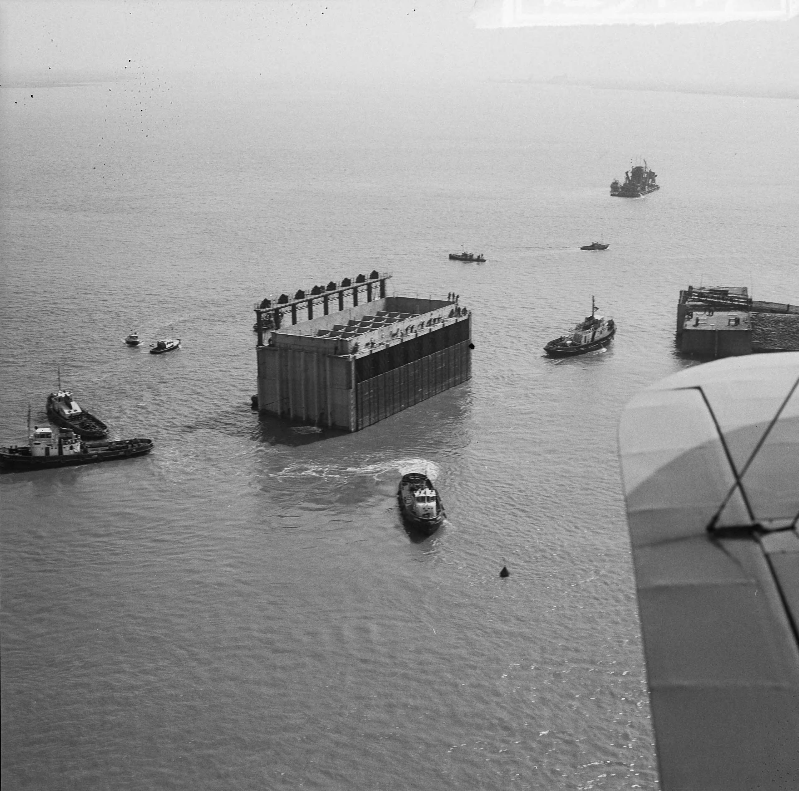 Fotocollectie Anefo — Luchtopnamen. Invaren van caissons in het Veerse Gat — Foto: Slagboom, Anton / Anefo. Licentie: Set B: Rechtenvrij / Publiek Domein. Bron: Nationaal Archief. http://hdl.handle.net/10648/a9d10dec-d0b4-102d-bcf8-003048976d84