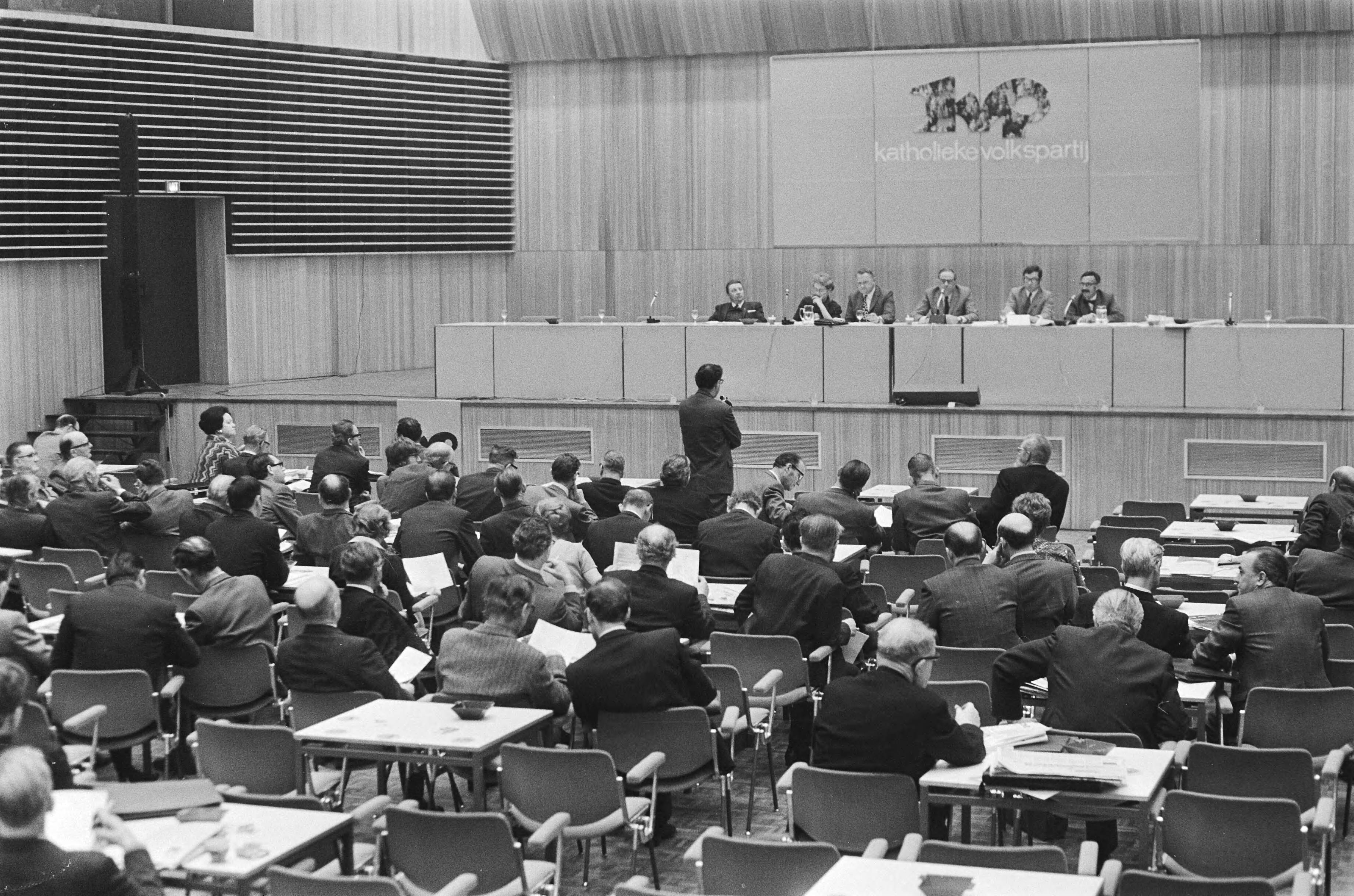 Partijraad van de KVP in Turfschip Breda over samenwerking met de VVD — Deelnemers tijdens de vergadering — Foto: Fotograaf Onbekend / Anefo. Licentie: Set B: Rechtenvrij / Publiek Domein. Bron: Nationaal Archief. http://hdl.handle.net/10648/abb90128-d0b4-102d-bcf8-003048976d84