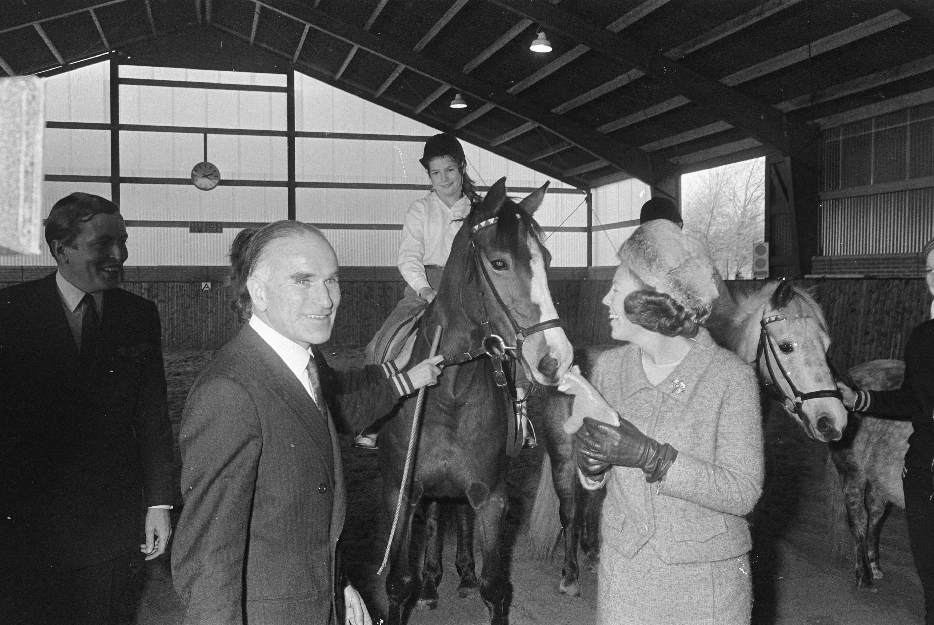 Fotocollectie Anefo — Prinses Beatrix en prins Claus opende Madurodam-manege te Den Haag . Na opening bood Lucy Dalhuizen prinses Beatrix een speelgoedpaardje aan — Foto: Koch, Eric / Anefo. Licentie: Set B: Rechtenvrij / Publiek Domein. Bron: Nationaal Archief. http://hdl.handle.net/10648/ab2ece22-d0b4-102d-bcf8-003048976d84