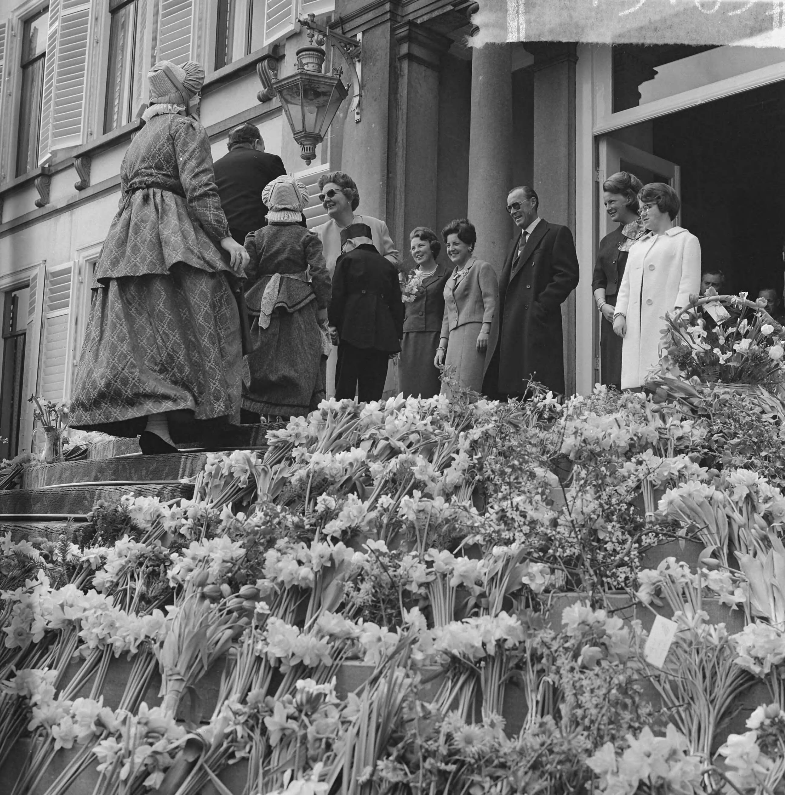 Koninginnedag 1963 — Koningin Juliana krijgt bloemen aangeboden door personen in klederdracht — Foto: Nijs, Jac. de / Anefo. Licentie: Set B: Rechtenvrij / Publiek Domein. Bron: Nationaal Archief. http://hdl.handle.net/10648/aa34a348-d0b4-102d-bcf8-003048976d84