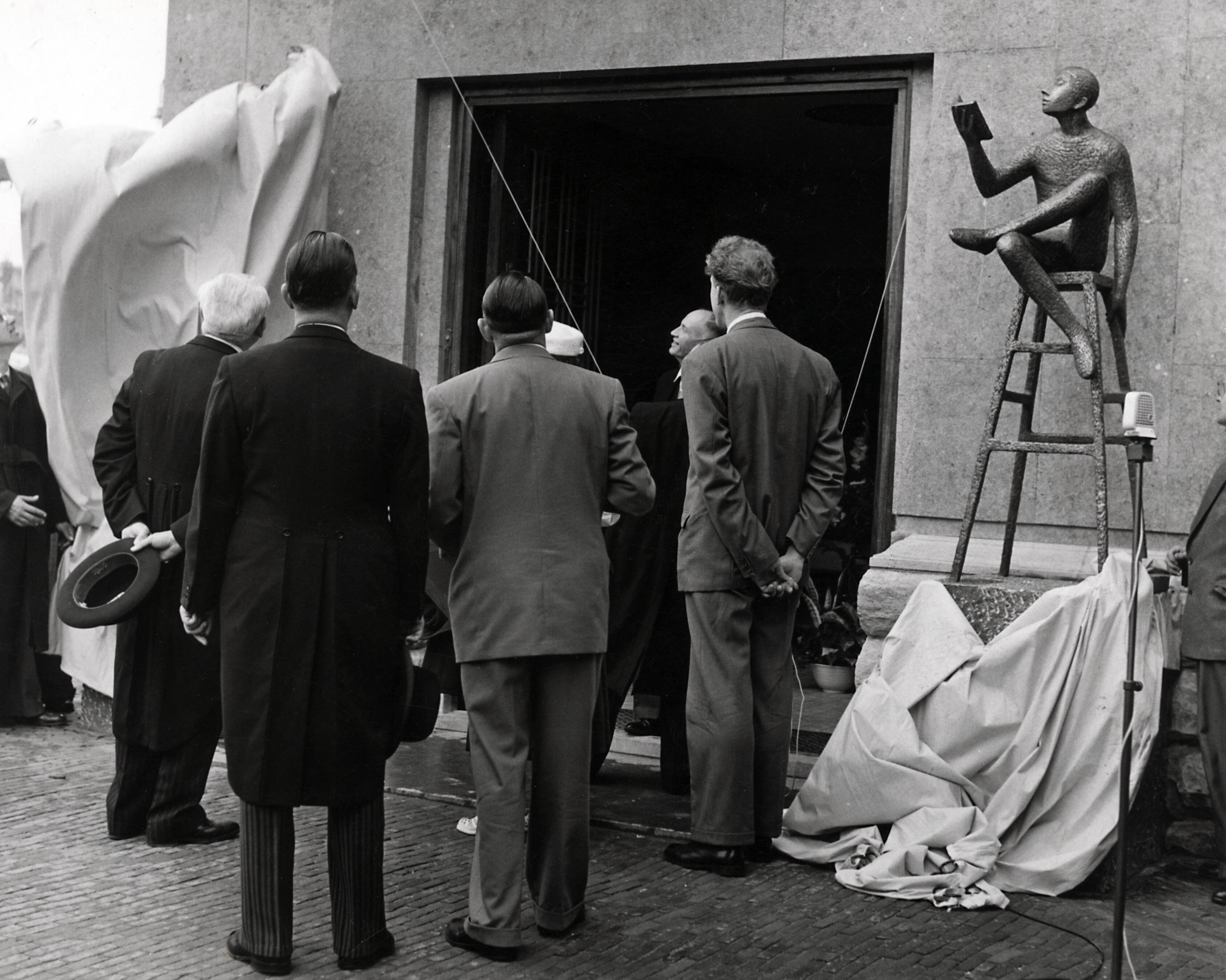 Collectie nader te bepalen — [50-jarig jubileum N.V. De Spaarnestad] [onthulling van de beelden van Hans Petri bij de hoofdingang van het Spaarnestadgebouw aan de Nassaulaan te Haarlem] — Foto: Fotograaf Onbekend / Fotobureau onbekend / Spaarnestad Photo (05887). Licentie: Set B: Rechtenvrij / Publiek Domein. Bron: Nationaal Archief. http://hdl.handle.net/10648/35429da6-3a88-a382-e063-6df0900a6686