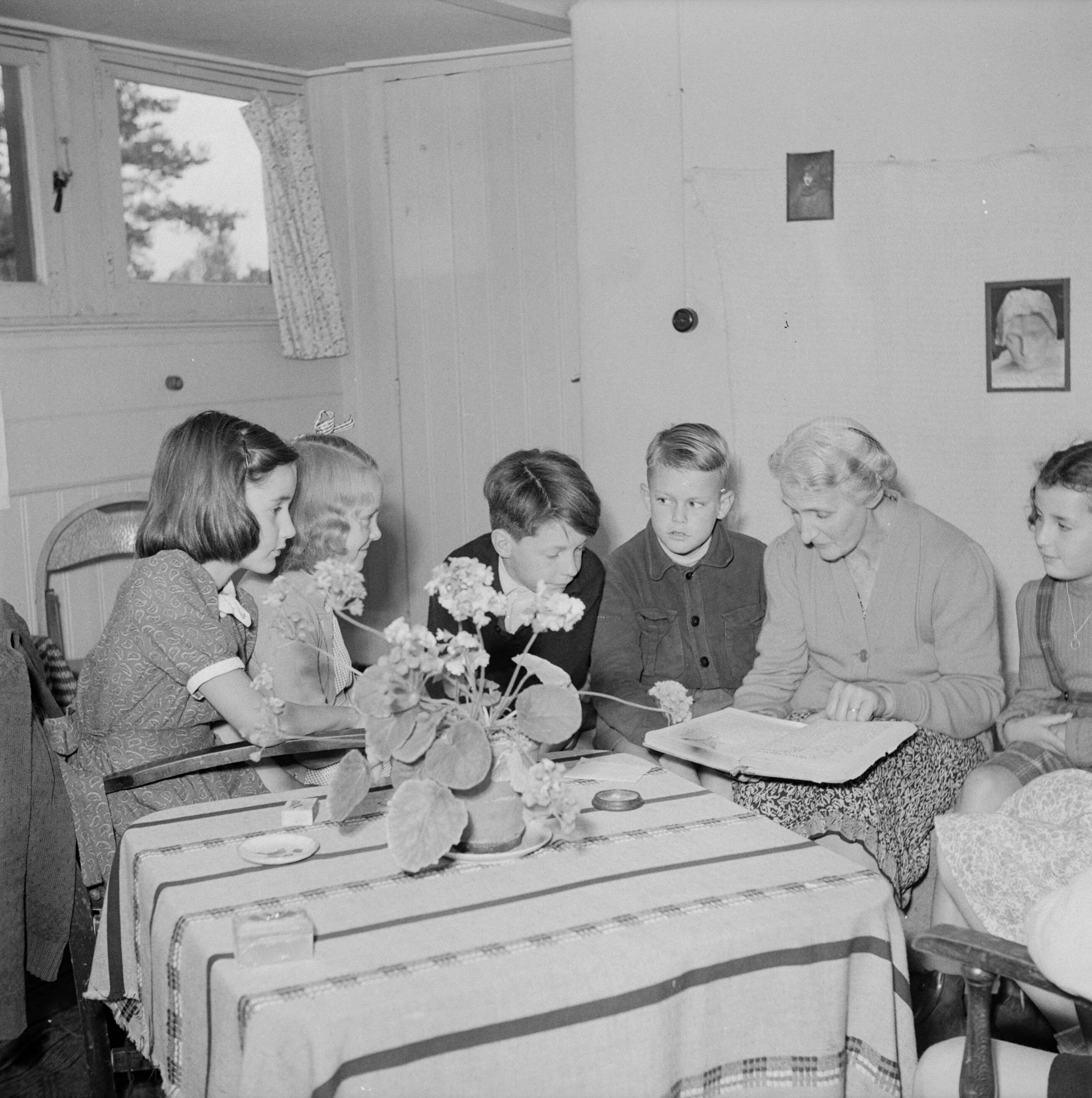Prinses Beatrix en prinses Irene op de Werkplaats Kindergemeenschap van Kees Boeke te Bilthoven — Prinses Irene en klasgenoten worden door Beatrice Boeke-Cadbury voorgelezen — Foto: Poll, Willem van de. Licentie: Set B: Rechtenvrij / Publiek Domein. Bron: Nationaal Archief. http://hdl.handle.net/10648/aee81e60-d0b4-102d-bcf8-003048976d84