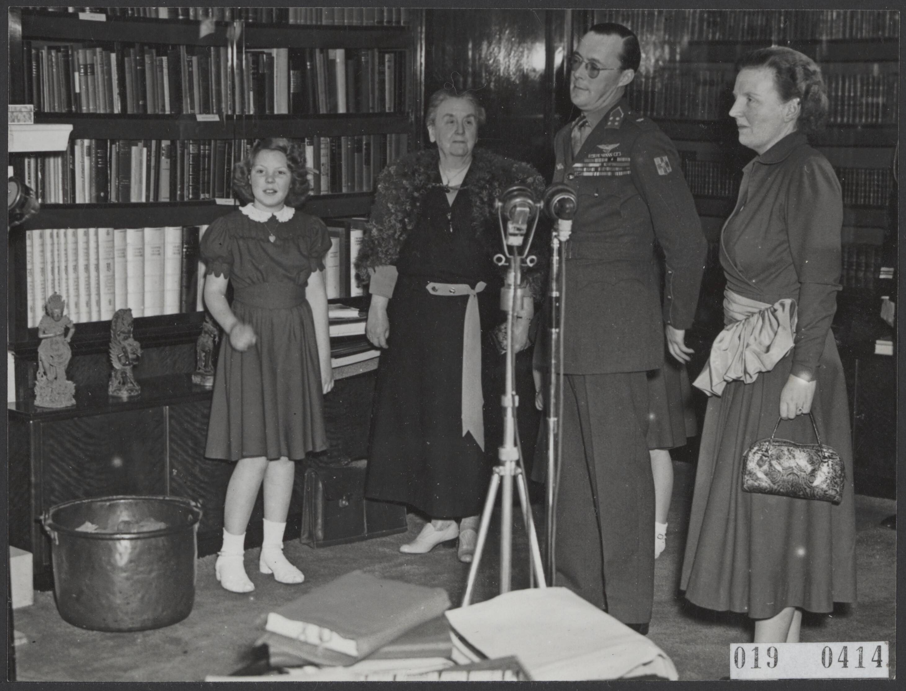 Fotocollectie Elsevier Binnenland — [In de bibiliotheek van paleis Soestdijk staan vlnr. prinses Beatrix, prinses Wilhelmina, prins Bernhard en koningin Juliana bij een microfoon van het Strijdkrachtenprogramma t.g.v. de Dag van de Strijdkrachten in Indonesië] — Foto: ANP / RVD of rechtenvrij. Licentie: Set B: Rechtenvrij / Publiek Domein. Bron: Nationaal Archief. http://hdl.handle.net/10648/adc6773e-d0b4-102d-bcf8-003048976d84