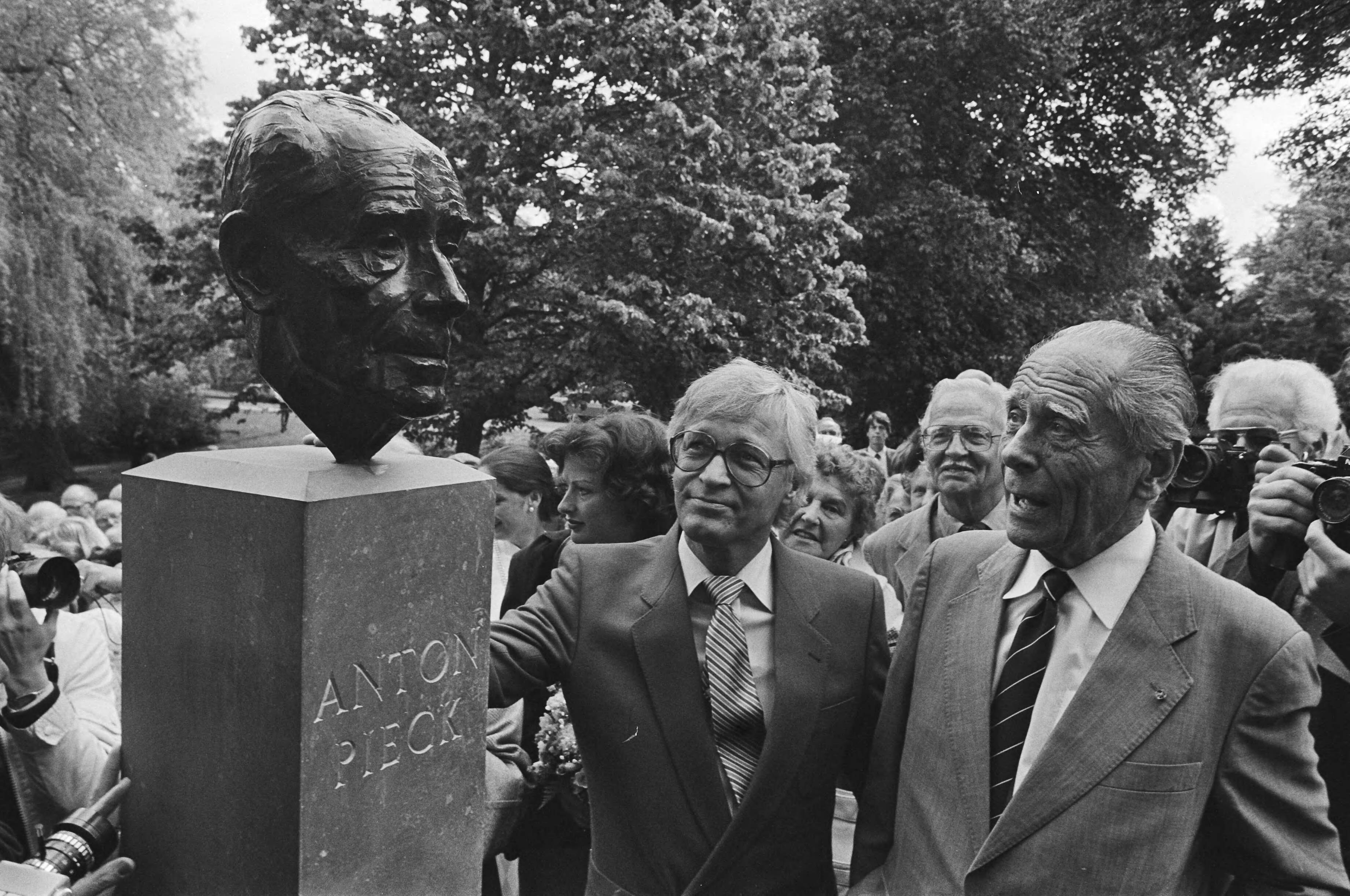 Onthulling van een beeld van Anton Pieck in Overveen — Anton Pieck (rechts) en beeldhouwer Kees Verkade bij de bronzen kop — Foto: Croes, Rob C. / Anefo. Licentie: Set B: Rechtenvrij / Publiek Domein. Bron: Nationaal Archief. http://hdl.handle.net/10648/ad2aba4c-d0b4-102d-bcf8-003048976d84