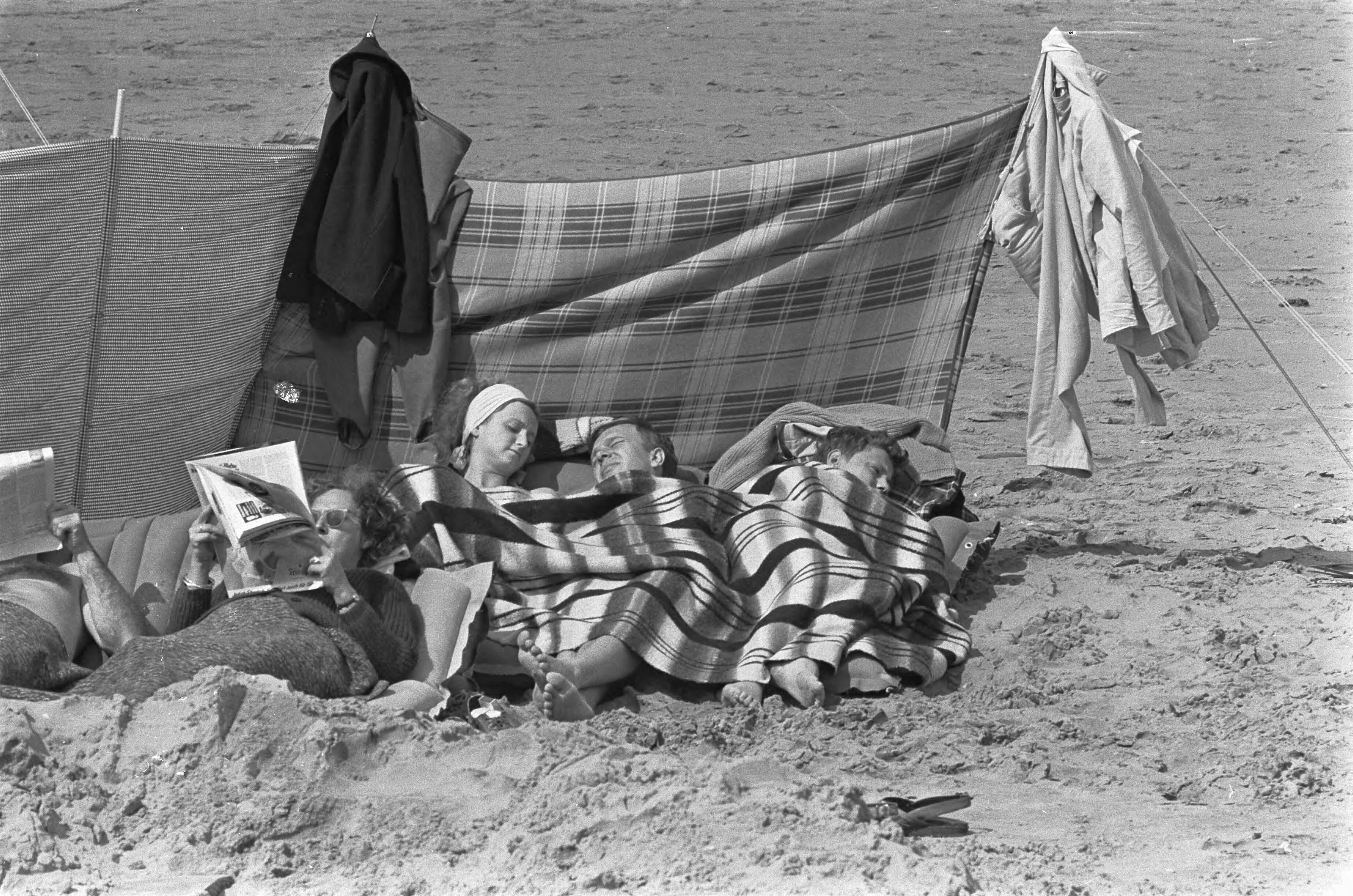 Fotocollectie Anefo — Zomer 1966, mensen op strand te Noordwijk aan het zonnen, onder dekens — Foto: Steinmeier, Hans / Anefo. Licentie: Set B: Rechtenvrij / Publiek Domein. Bron: Nationaal Archief. http://hdl.handle.net/10648/aaf50b1a-d0b4-102d-bcf8-003048976d84
