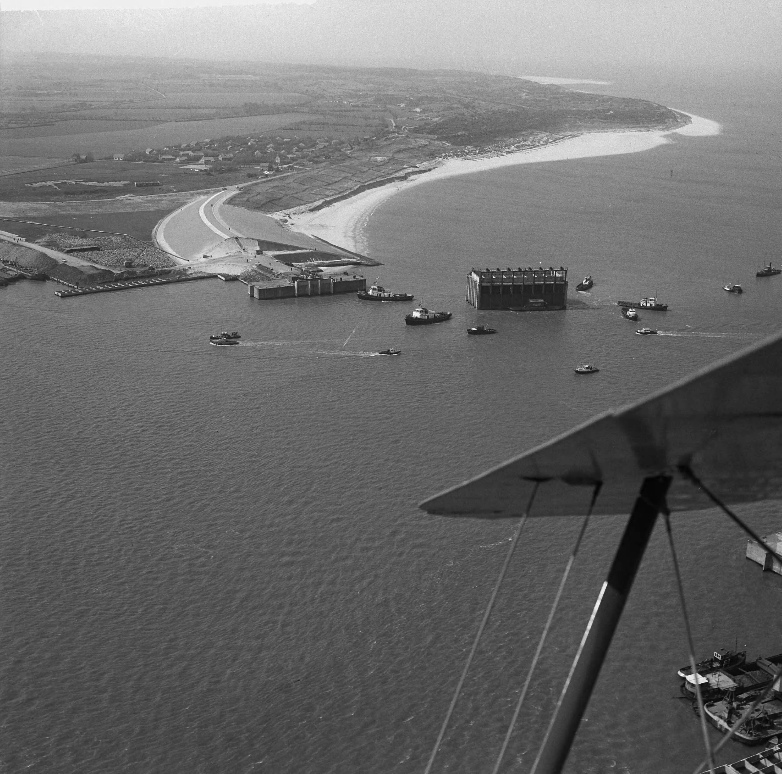 Fotocollectie Anefo — Luchtopnamen. Invaren van caissons in het Veerse Gat — Foto: Slagboom, Anton / Anefo. Licentie: Set B: Rechtenvrij / Publiek Domein. Bron: Nationaal Archief. http://hdl.handle.net/10648/a9d11030-d0b4-102d-bcf8-003048976d84