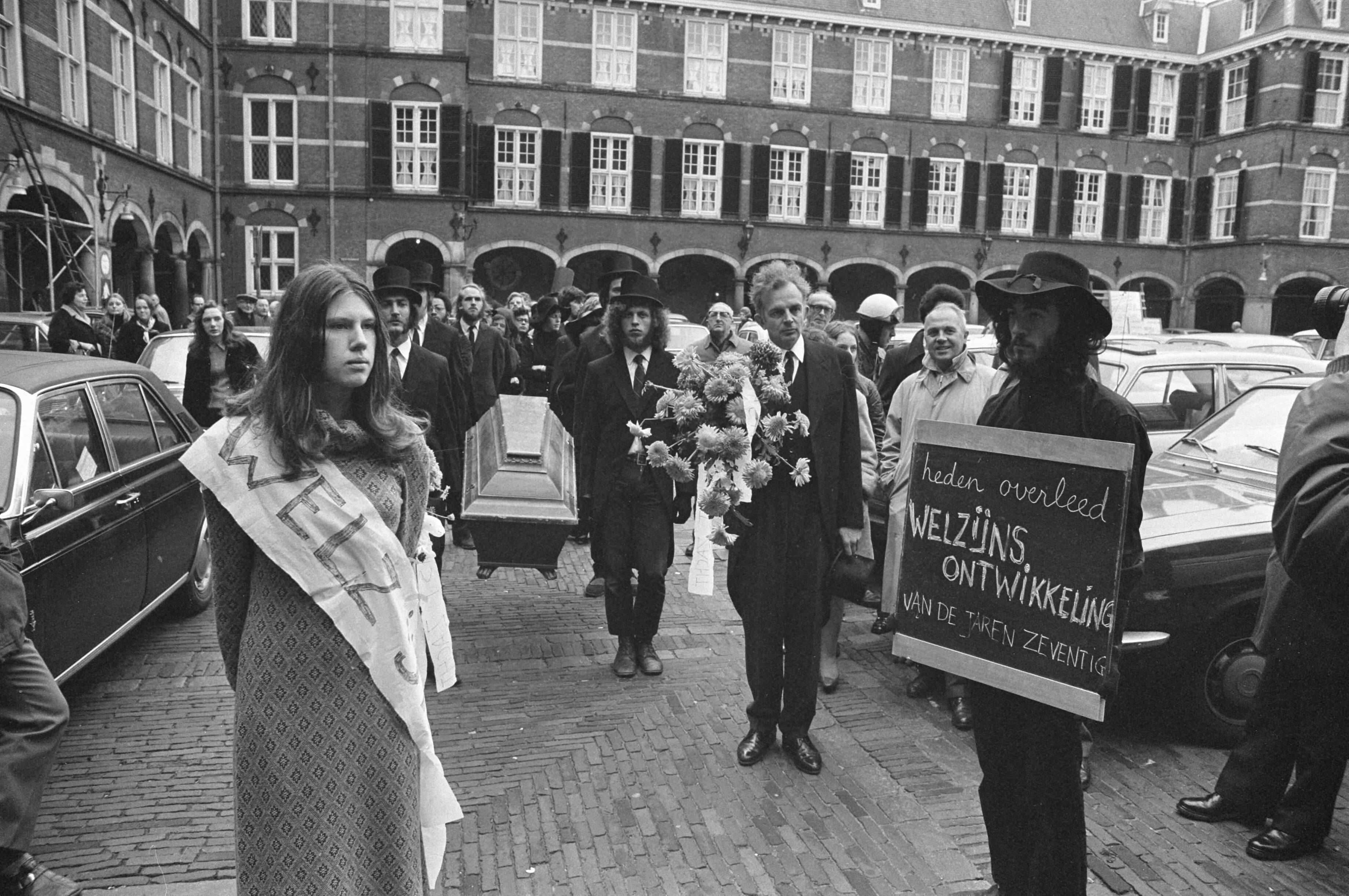 Fotocollectie Anefo — Demonstratie van anti-CRM bezuinigingsfront met doodkist Binnenhof Den Haag , begrafenisstoet — Foto: Evers, Joost / Anefo. Licentie: Set B: Rechtenvrij / Publiek Domein. Bron: Nationaal Archief. http://hdl.handle.net/10648/abd74e26-d0b4-102d-bcf8-003048976d84