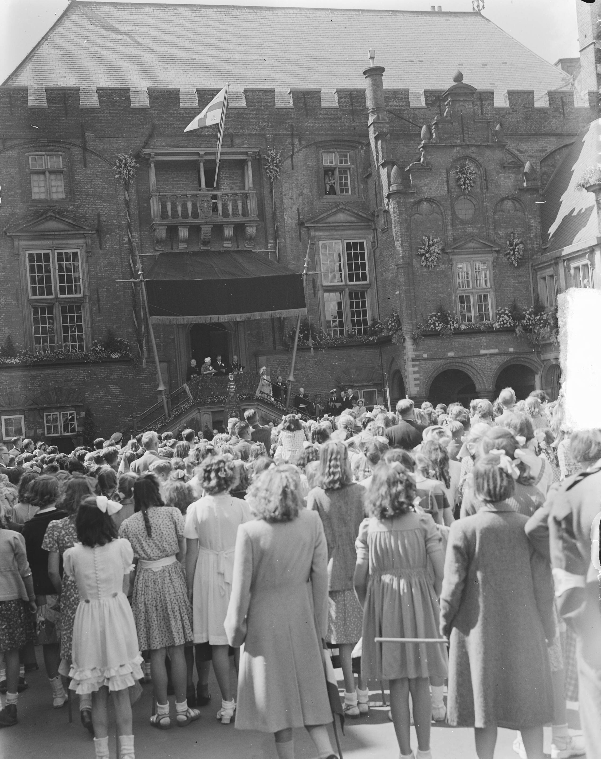 Koningin Juliana en prins Bernhard in Haarlem — Zanghulde voor het koninklijk paar — Foto: Bilsen, Joop van / Anefo. Licentie: Set B: Rechtenvrij / Publiek Domein. Bron: Nationaal Archief. http://hdl.handle.net/10648/a8cb2a04-d0b4-102d-bcf8-003048976d84