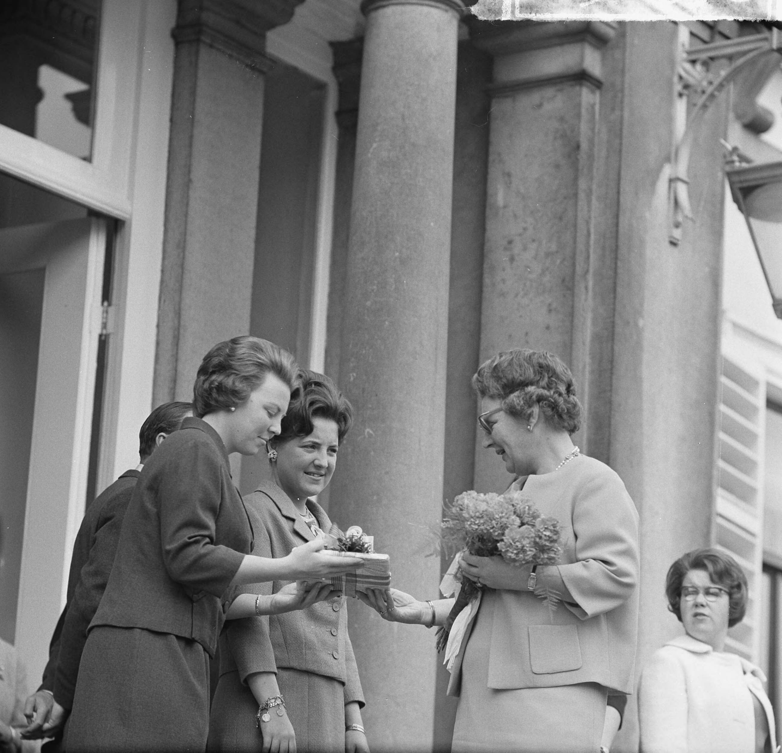Koninginnedag 1963 — Prinsessen Beatrix en Margriet en koningin Juliana bekijken een geschenk. Rechts op het bordes prinses Christina — Foto: Nijs, Jac. de / Anefo. Licentie: Set B: Rechtenvrij / Publiek Domein. Bron: Nationaal Archief. http://hdl.handle.net/10648/aa34948e-d0b4-102d-bcf8-003048976d84