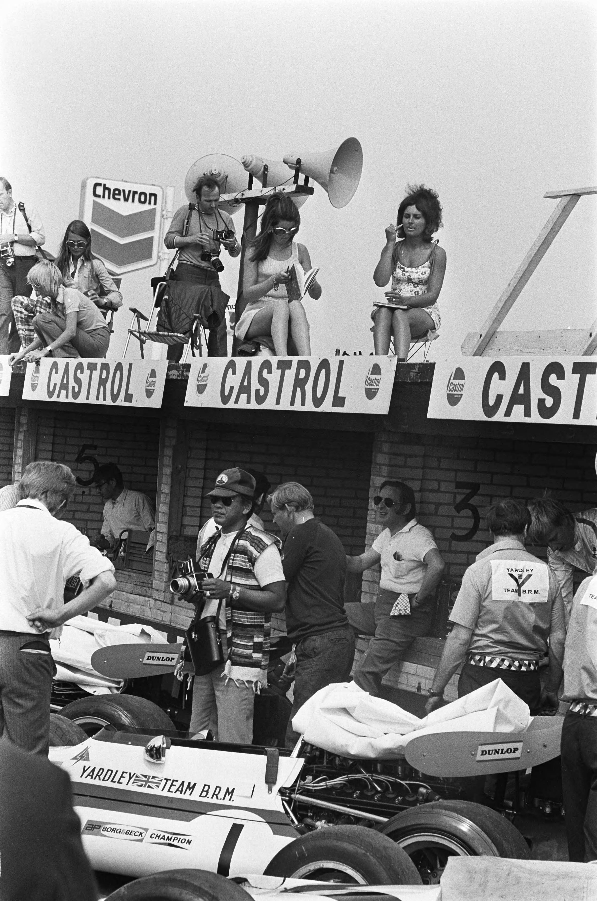 Grand Prix Zandvoort 1970, training — Grand Prix 1970 voor Formule I wagens te Zandvoort; eerste trainingsdag; "Pitspoezen' en fotografen — Foto: Evers, Joost / Anefo. Licentie: Set B: Rechtenvrij / Publiek Domein. Bron: Nationaal Archief. http://hdl.handle.net/10648/ab9a071e-d0b4-102d-bcf8-003048976d84