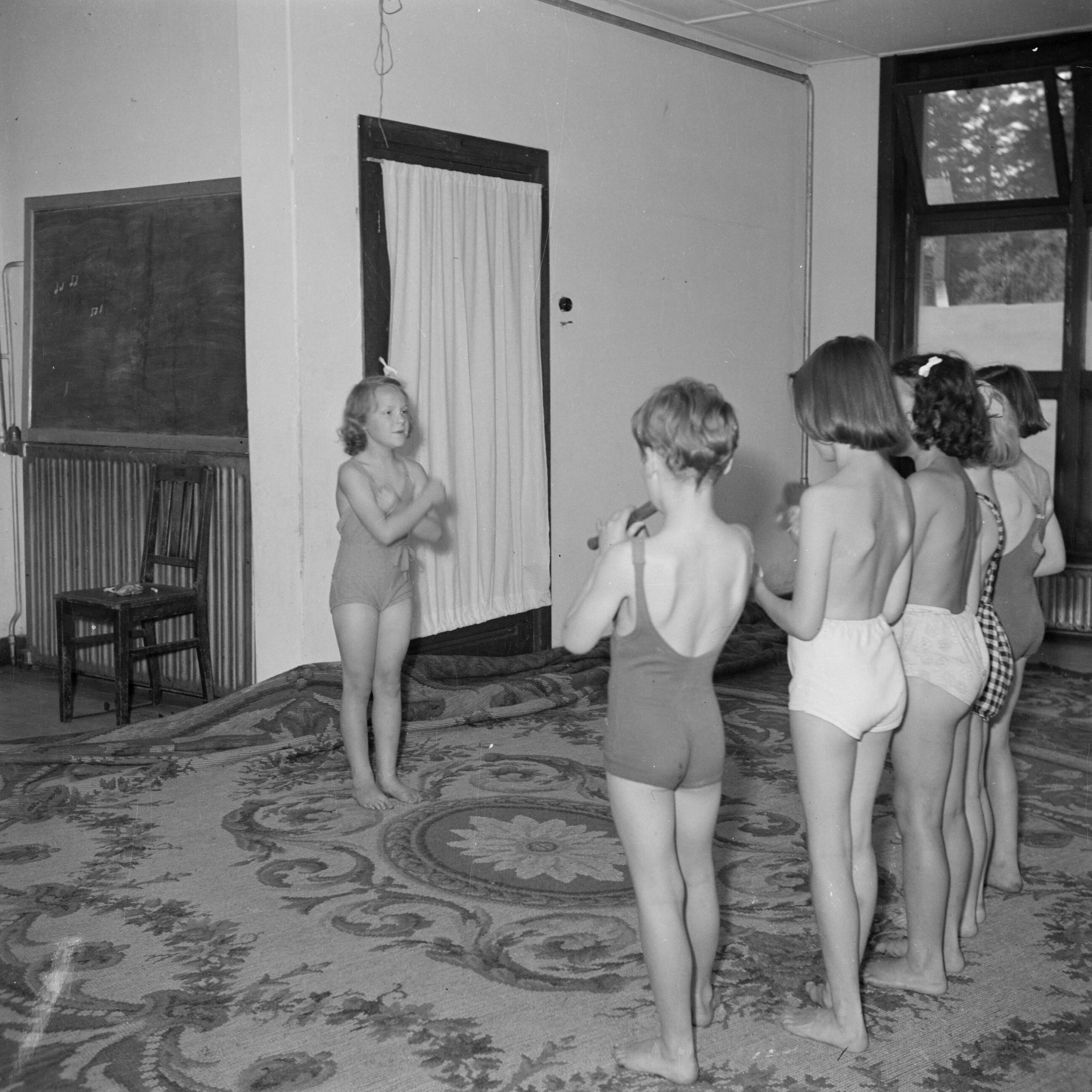 Prinses Beatrix en prinses Irene op de Werkplaats Kindergemeenschap van Kees Boeke te Bilthoven — Prinses Irene en klasgenoten maken muziek in gymkleding — Foto: Poll, Willem van de. Licentie: Set B: Rechtenvrij / Publiek Domein. Bron: Nationaal Archief. http://hdl.handle.net/10648/aee812f8-d0b4-102d-bcf8-003048976d84