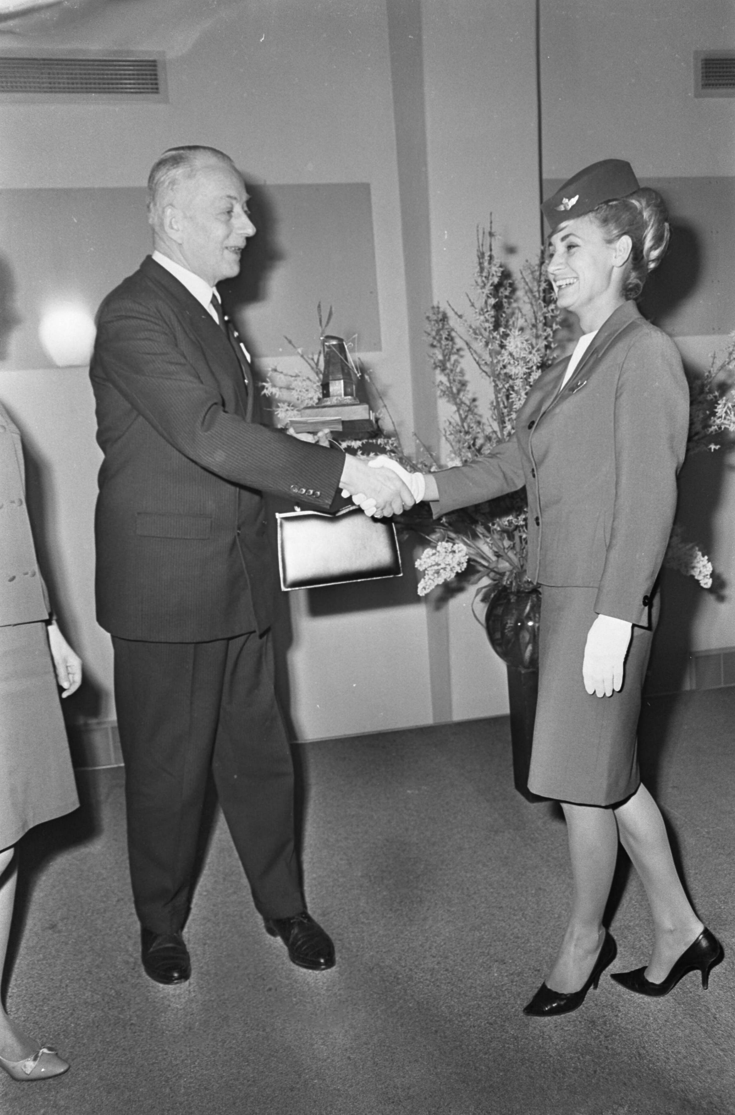 Fotocollectie Anefo — Internationale souvenirsbeurs te Utrecht, wintervakbeurs koffers en lederwaren, Burgemeester De Ranitz geeft tas aan KLM-stewardess — Foto: Nijs, Jac. de / Anefo. Licentie: Set B: Rechtenvrij / Publiek Domein. Bron: Nationaal Archief. http://hdl.handle.net/10648/ab0a867a-d0b4-102d-bcf8-003048976d84