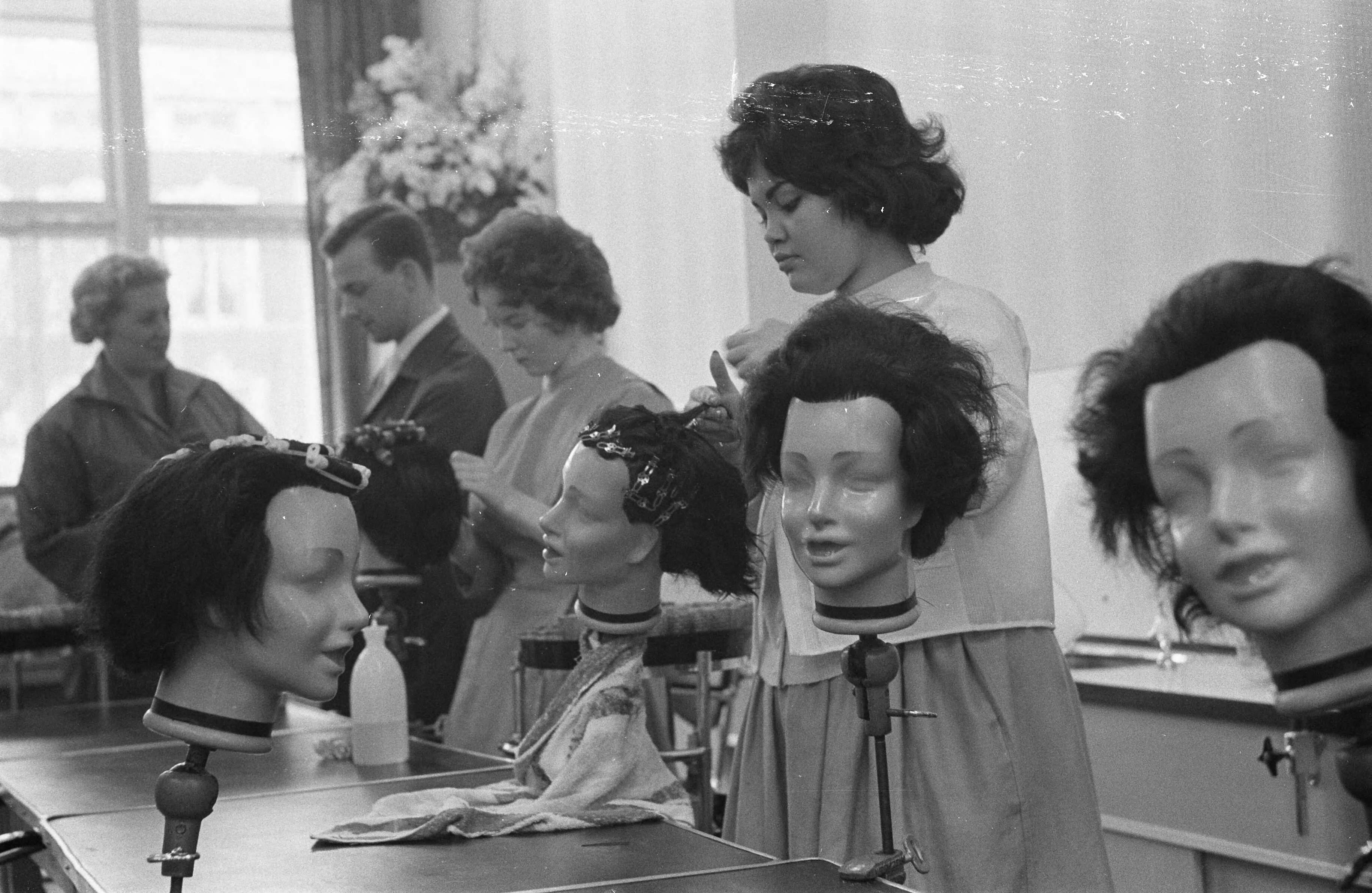 Fotocollectie Anefo — Opening van de eerste kappersdagschool aan de Prinses Marijkestraat te Den Haag , enige leerlingen aan het oefenen — Foto: Pot, Harry / Anefo. Licentie: Set B: Rechtenvrij / Publiek Domein. Bron: Nationaal Archief. http://hdl.handle.net/10648/a9a90e28-d0b4-102d-bcf8-003048976d84