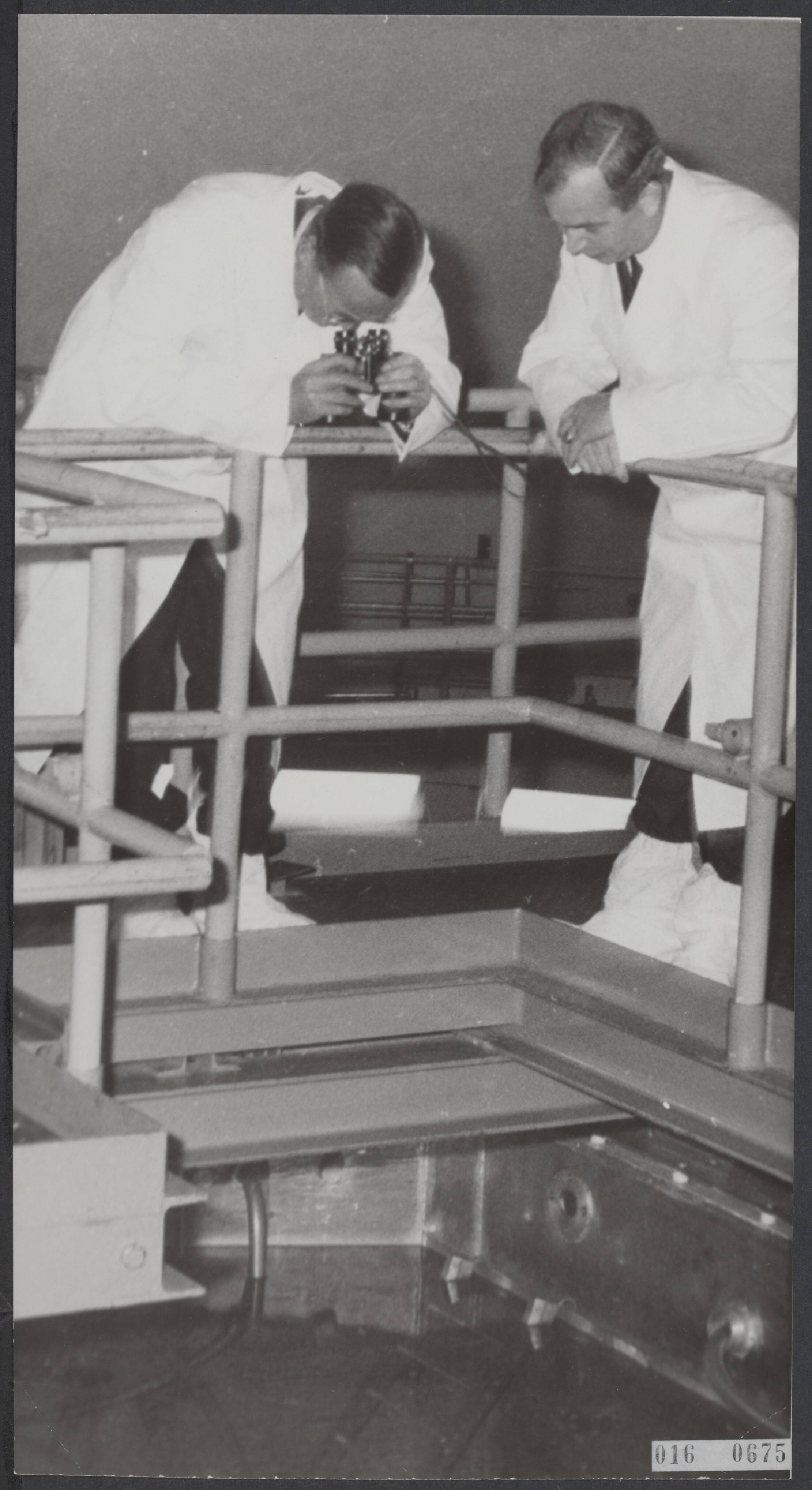 Fotocollectie Elsevier Binnenland — Officiële opening van het laboratorium voor sterk-radioactieve opbjecten in het Reactor Centrum te Petten door Prins Bernhard. Prins Bernhard op de brug, gewapend met witte jas, witte sloffen en een verrekijke, dit alles om de stralingsonderzoekingen in een diep waterbassin onder hem te bezichtigen. Naast de prins een der technische medewerkers van het reactorcentrum in Petten — Foto: Nijs, Jac. de / Anefo. Licentie: Set B: Rechtenvrij / Publiek Domein. Bron: Nationaal Archief. http://hdl.handle.net/10648/adba185e-d0b4-102d-bcf8-003048976d84