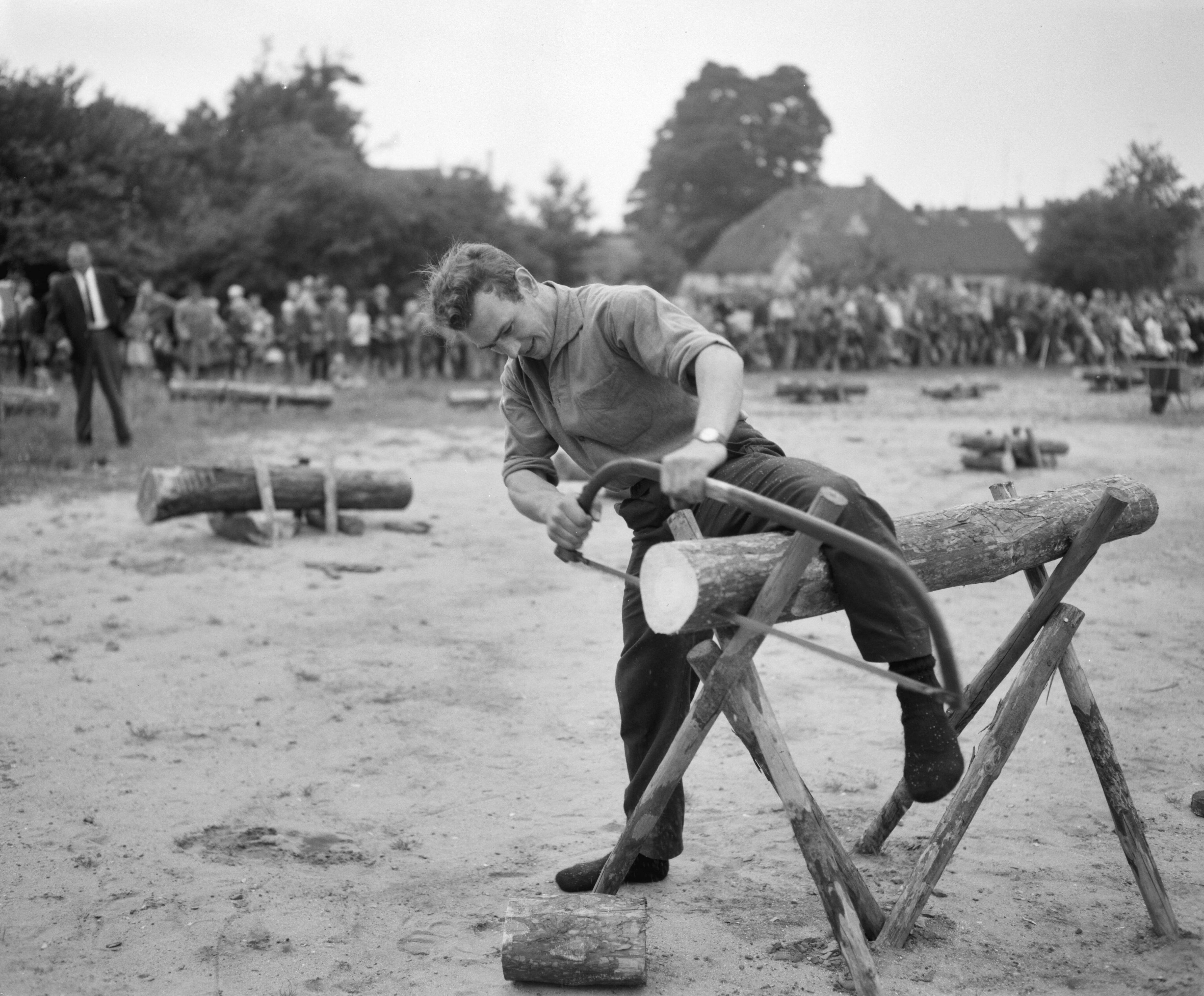 Fotocollectie Anefo — Nationale boomzaagwedstrijden in Ede. Op de ouderwetse manier — Foto: Bilsen, Joop van / Anefo. Licentie: Set B: Rechtenvrij / Publiek Domein. Bron: Nationaal Archief. http://hdl.handle.net/10648/aa14be8e-d0b4-102d-bcf8-003048976d84