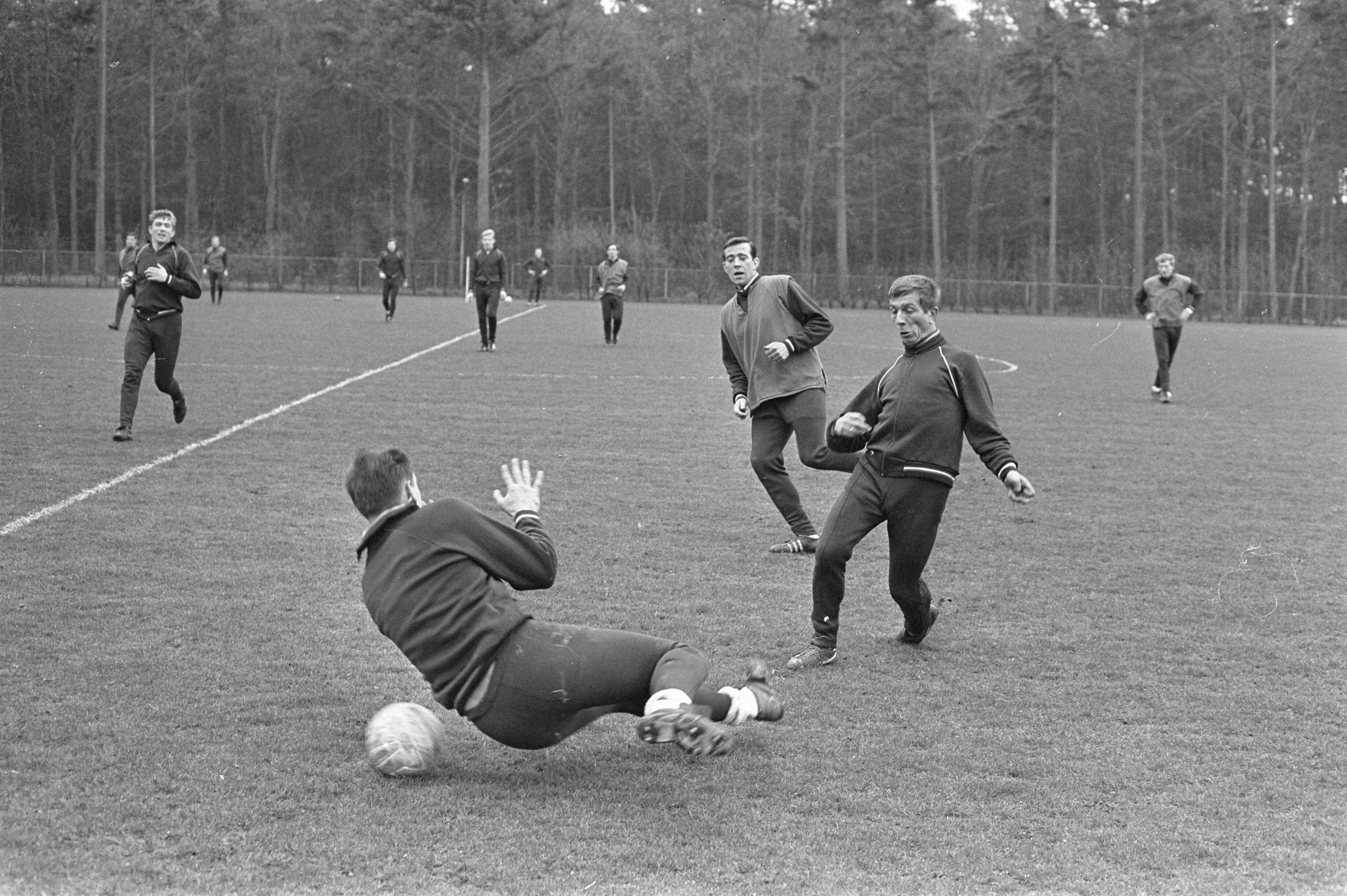 Fotocollectie Anefo — Training Nederlands elftal te Zeist, Flinkevleugel en Schrijvers schieten op Tony van Leeuwen — Foto: Nijs, Jac. de / Anefo. Licentie: Set B: Rechtenvrij / Publiek Domein. Bron: Nationaal Archief. http://hdl.handle.net/10648/ab130066-d0b4-102d-bcf8-003048976d84