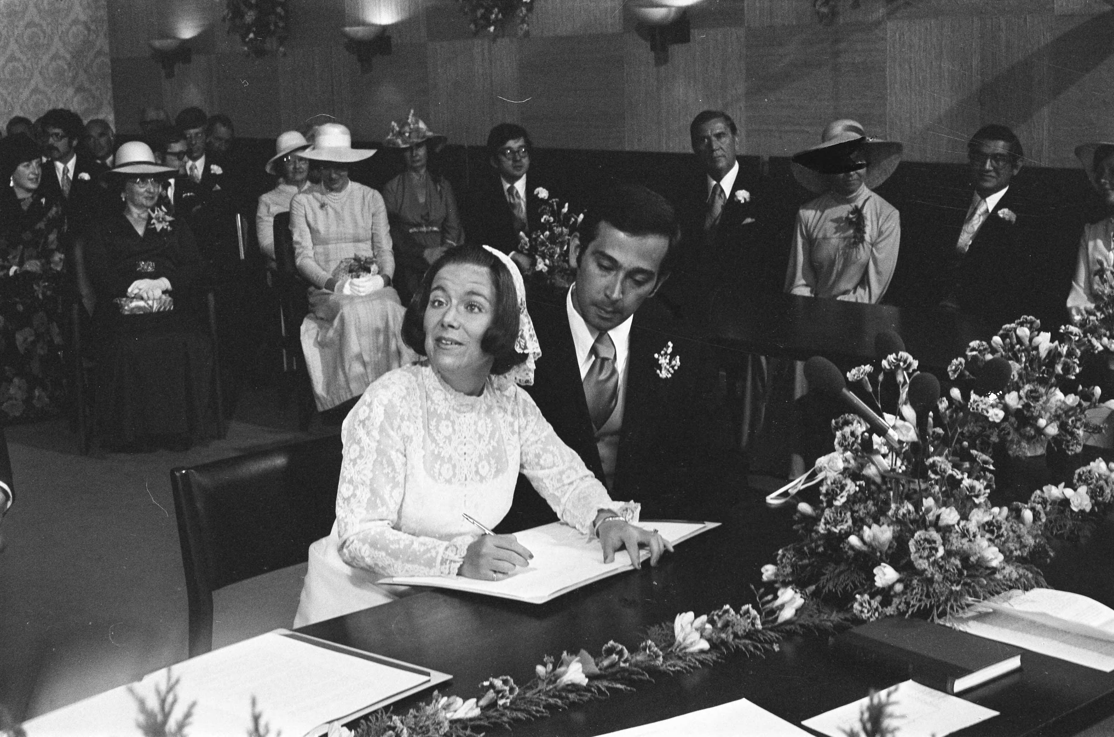 Huwelijk prinses Christina en Jorge Guillermo; de sluiting van het burgerlijk huwelijk in het stadhuis van Baarn — Prinses Christina en Jorge Guillermo tekenen de huwelijksakte bij de sluiting van het burgerlijk huwelijk — Foto: Meerdere fotografen / Anefo. Licentie: Set B: Rechtenvrij / Publiek Domein. Bron: Nationaal Archief. http://hdl.handle.net/10648/ac6c5c46-d0b4-102d-bcf8-003048976d84