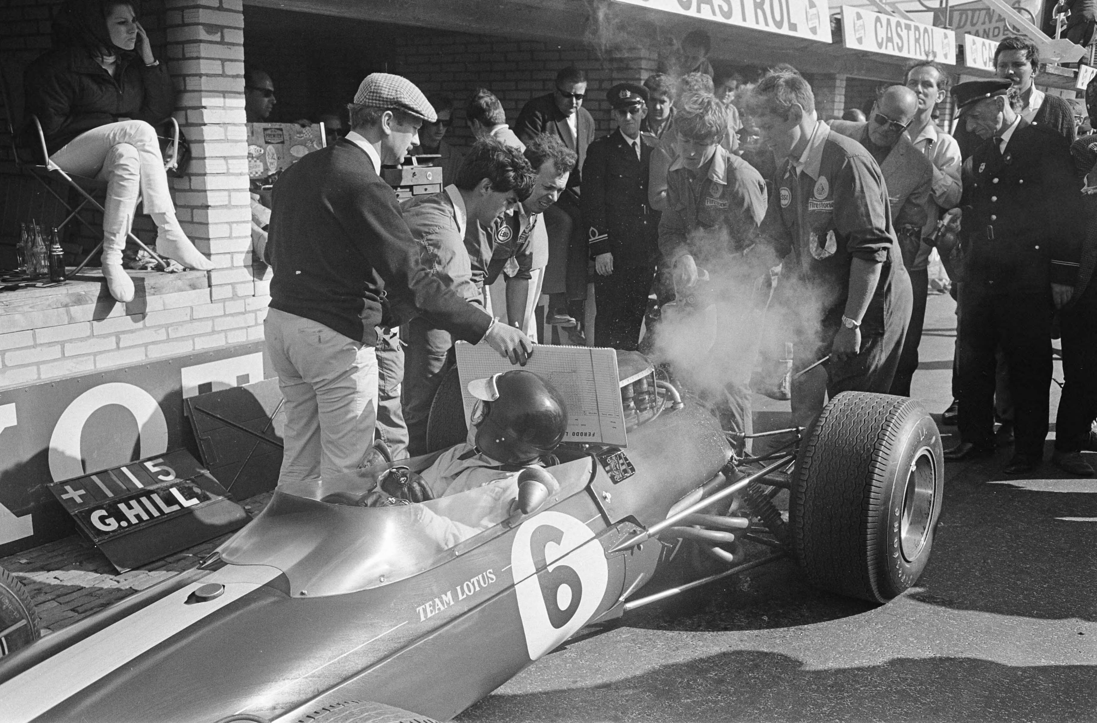 Fotocollectie Anefo — Grand Prix te Zandvoort, Jim Clark , pitsstop gemaakt om koelwater bij te tanken, met pet Collin Chapman — Foto: Koch, Eric / Anefo. Licentie: Set B: Rechtenvrij / Publiek Domein. Bron: Nationaal Archief. http://hdl.handle.net/10648/aaf3ccbe-d0b4-102d-bcf8-003048976d84