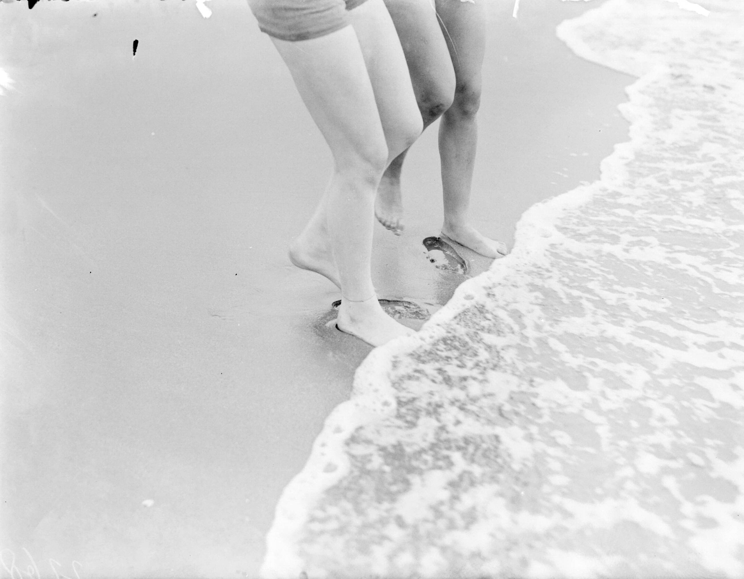 Reportage fotomodel — De benen en voeten van model Eva Waldschmidt en Nell Langlais in het zeewater — Foto: Poll, Willem van de. Licentie: Set B: Rechtenvrij / Publiek Domein. Bron: Nationaal Archief. http://hdl.handle.net/10648/aea80186-d0b4-102d-bcf8-003048976d84