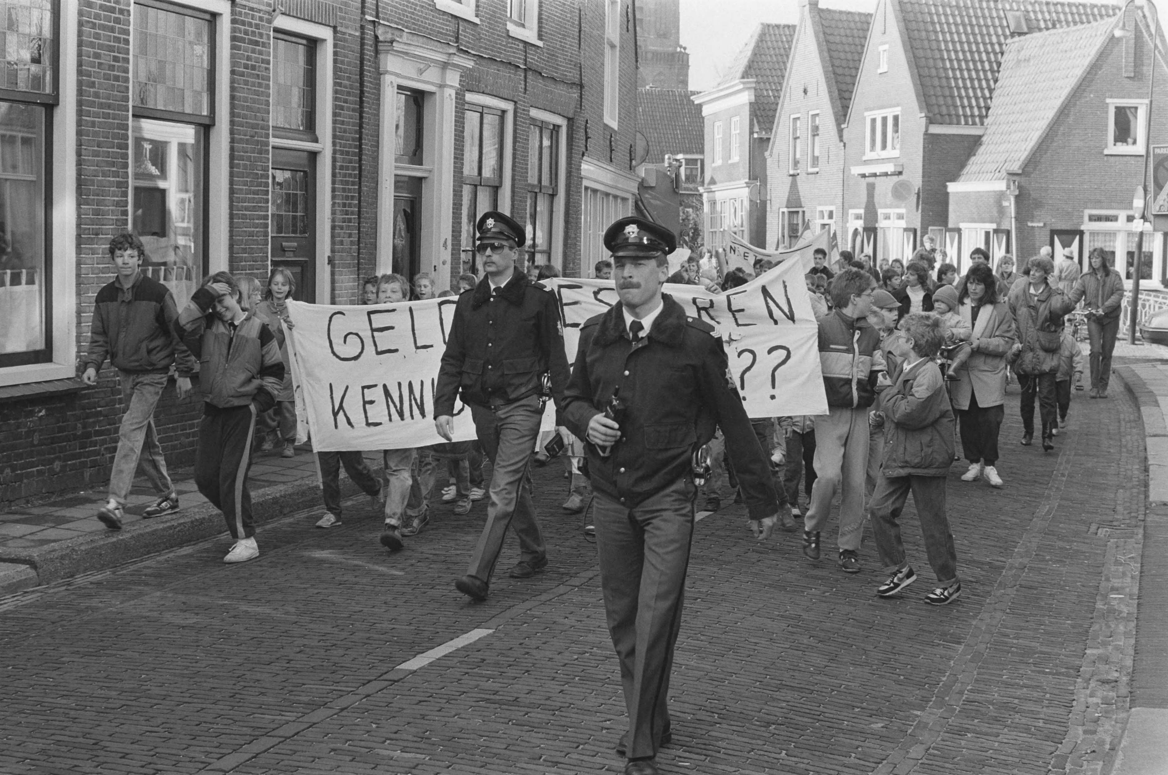 Fotocollectie Anefo — Leerlingen basisscholen Monnickendam demonstreren tegen wachtdagen bij vervangen zieke leerkrachten; politie begeleidt de kinderdemonstratie — Foto: Gerrits, Roland / Anefo. Licentie: Set B: Rechtenvrij / Publiek Domein. Bron: Nationaal Archief. http://hdl.handle.net/10648/ad5ef0fa-d0b4-102d-bcf8-003048976d84