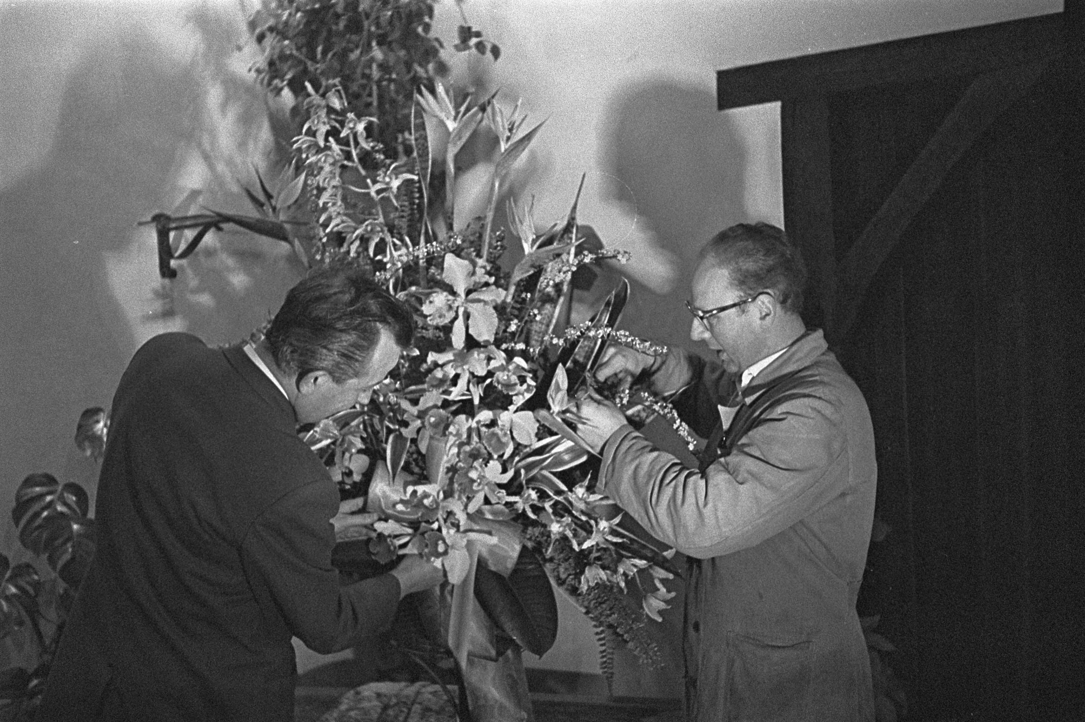 Fotocollectie Anefo — Flowershop te Haarlem levert elf bloemstukken voor het huwelijk van de Sjah van Perzië, de heren Holsken (l) en Schrama (r) aan het schikken — Foto: Pot, Harry / Anefo. Licentie: Set B: Rechtenvrij / Publiek Domein. Bron: Nationaal Archief. http://hdl.handle.net/10648/a9a3ea24-d0b4-102d-bcf8-003048976d84