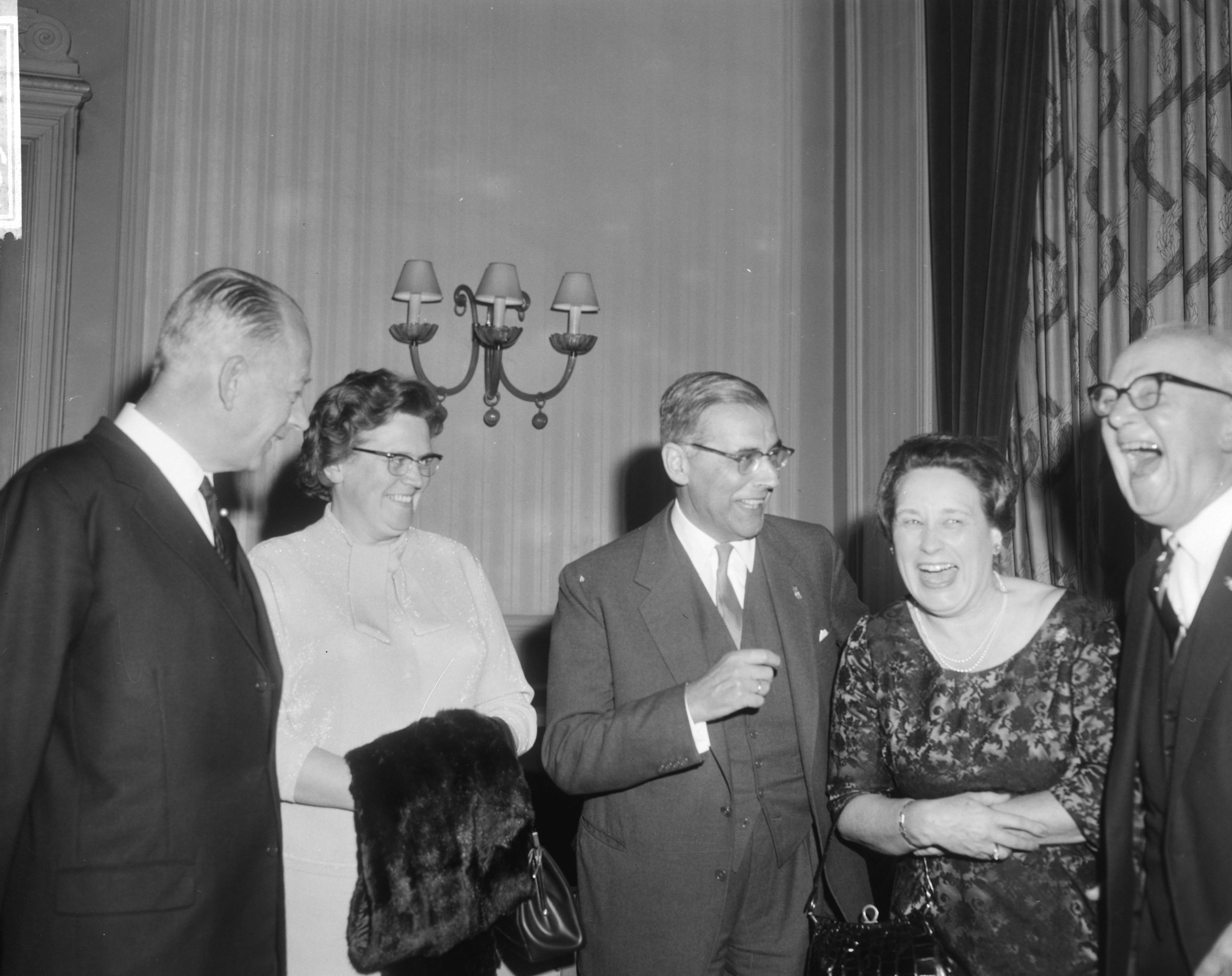 Viering van het tienjarig jubileum van het Nederlands Genootschap van Burgemeesters in het Kurhaus te Scheveningen — Burgemeester van Amsterdam Van Hall (midden) en Burgemeester Kolfschoten van Den Haag (rechts) in gezelschap van twee burgemeestersvrouwen — Foto: Bilsen, Joop van / Anefo. Licentie: Set B: Rechtenvrij / Publiek Domein. Bron: Nationaal Archief. http://hdl.handle.net/10648/aac66d46-d0b4-102d-bcf8-003048976d84