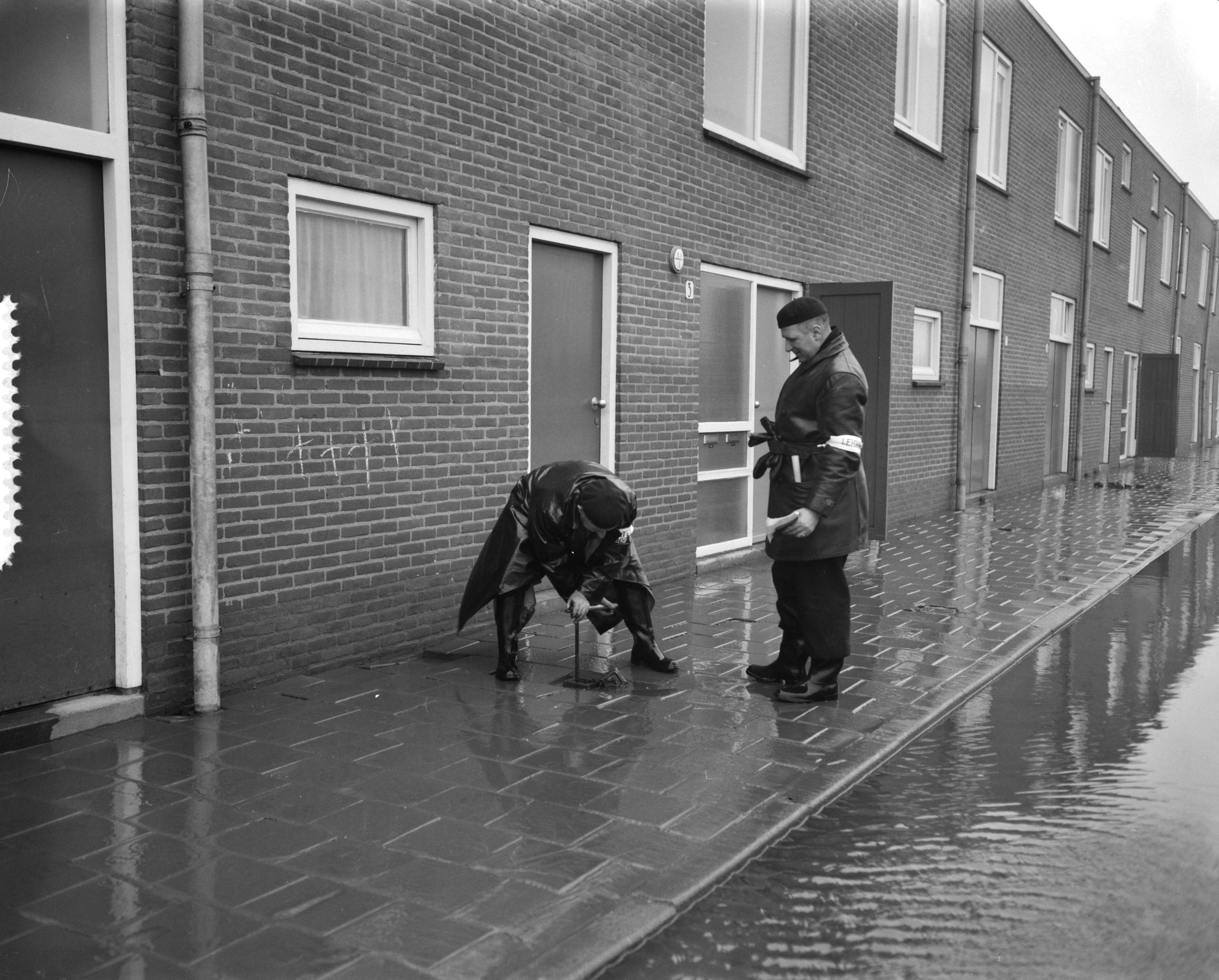 Ramp Tuindorp Oostzaan — Persrondgang door rampgebied Oostzaan, afsluiten hoofdkraan — Foto: Bilsen, Joop van / Anefo. Licentie: Set B: Rechtenvrij / Publiek Domein. Bron: Nationaal Archief. http://hdl.handle.net/10648/a9a64044-d0b4-102d-bcf8-003048976d84