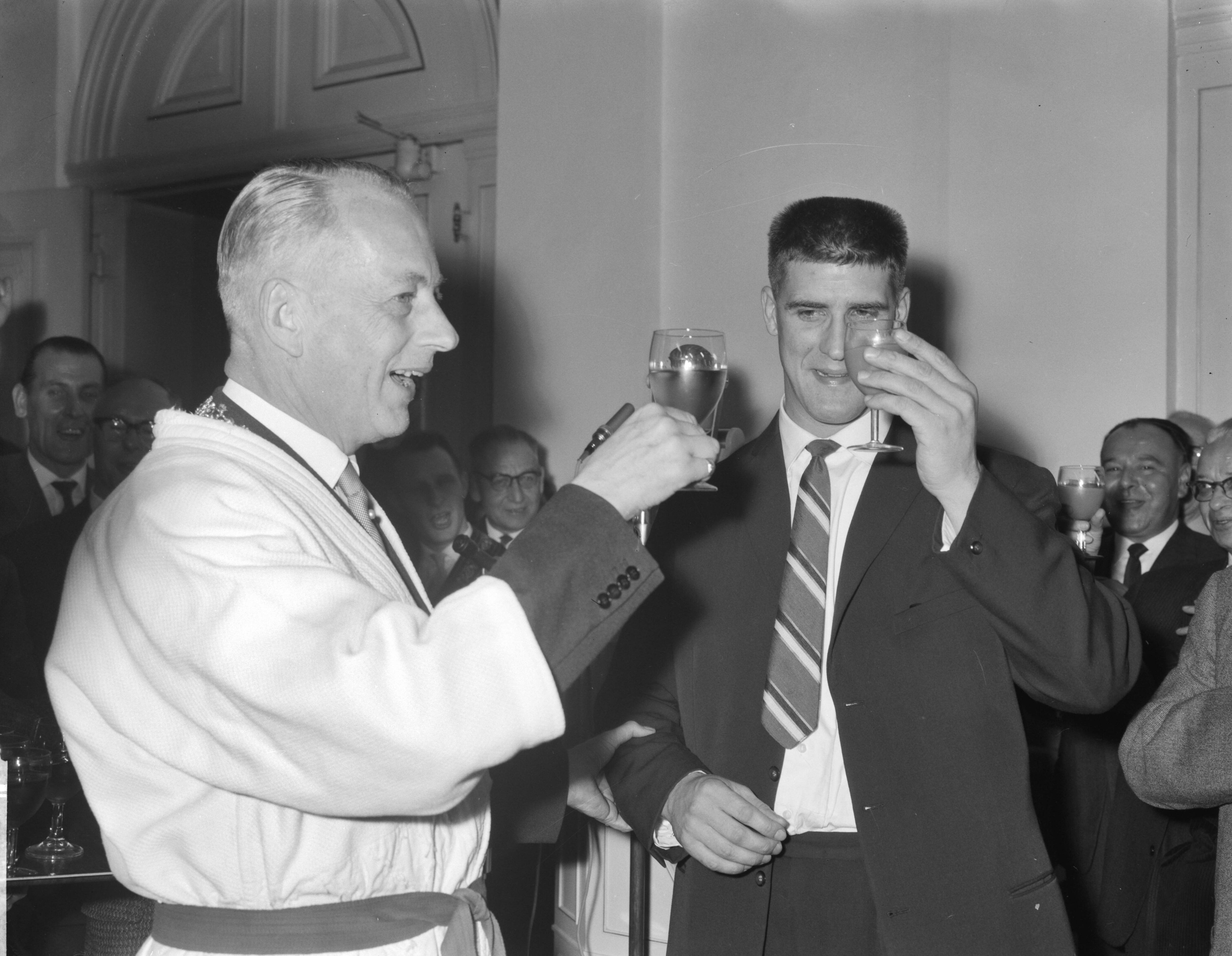 Fotocollectie Anefo — Huldiging van Anton Geesink op het stadhuis van Utrecht. Anton Geesink en burgemeester De Ranitz (in judopak) toosten — Foto: Rossem, Wim van / Anefo. Licentie: Set B: Rechtenvrij / Publiek Domein. Bron: Nationaal Archief. http://hdl.handle.net/10648/a9eedf34-d0b4-102d-bcf8-003048976d84