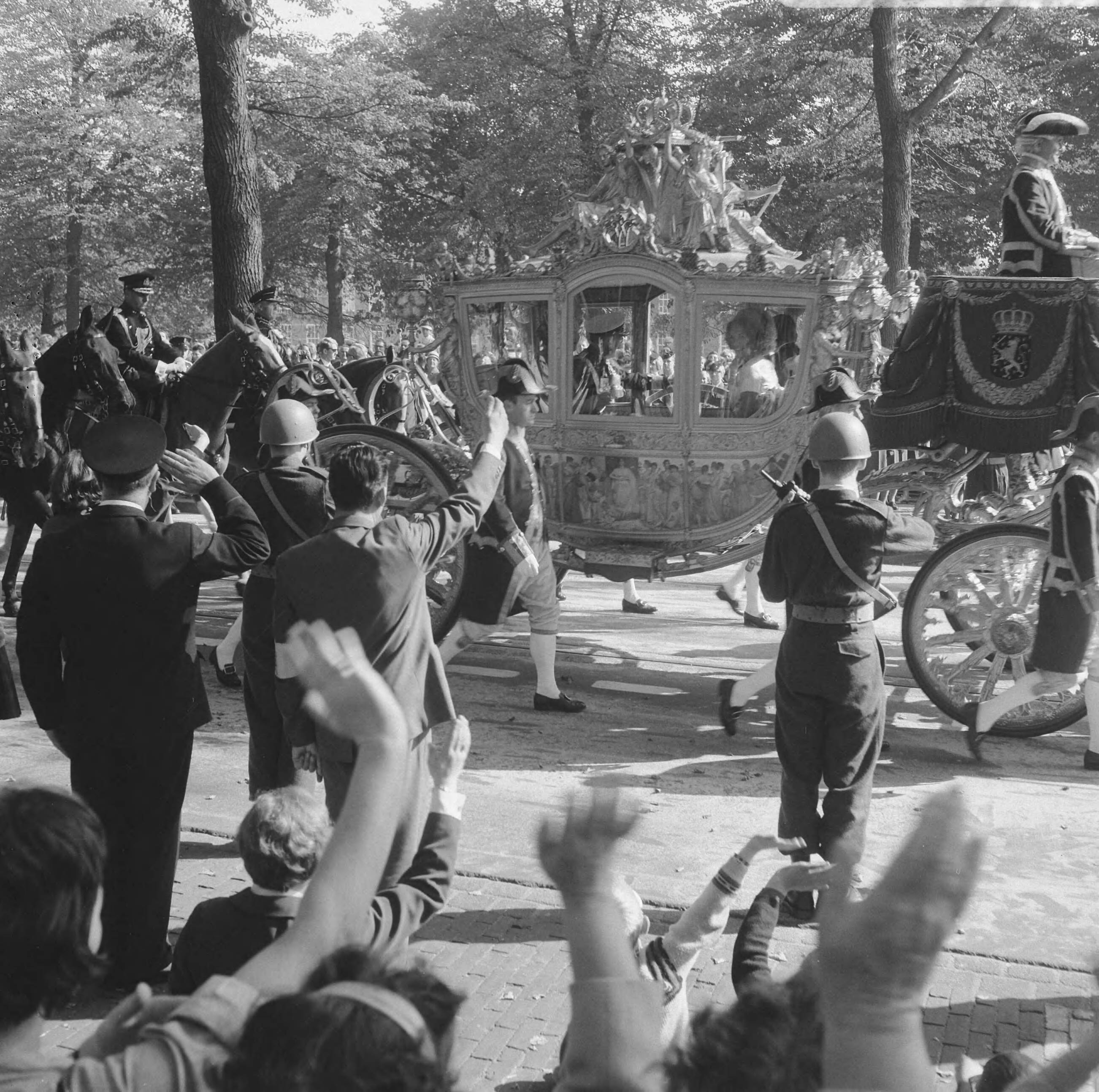 Prinsjesdag 1966 in Den Haag — Mensen zwaaiend naar de Gouden Koets op weg naar de Ridderzaal — Foto: Kroon, Ron / Anefo. Licentie: Set B: Rechtenvrij / Publiek Domein. Bron: Nationaal Archief. http://hdl.handle.net/10648/aafd1f1c-d0b4-102d-bcf8-003048976d84