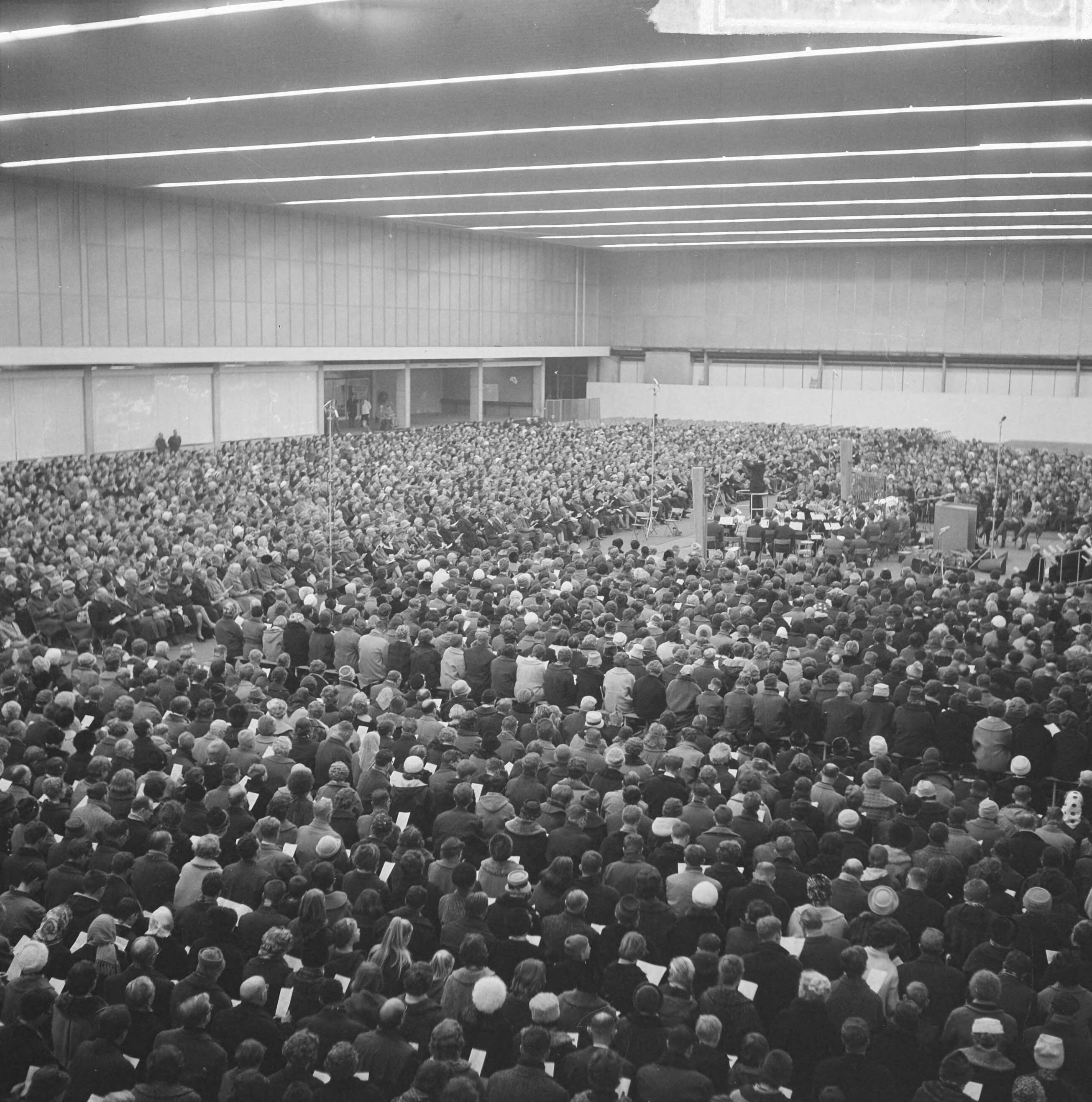Fotocollectie Anefo — Massale volkskerstzang in de Zuidhal van het RAI-gebouw te Amsterdam — Foto: Nijs, Jac. de / Anefo. Licentie: Set B: Rechtenvrij / Publiek Domein. Bron: Nationaal Archief. http://hdl.handle.net/10648/aa2387d4-d0b4-102d-bcf8-003048976d84
