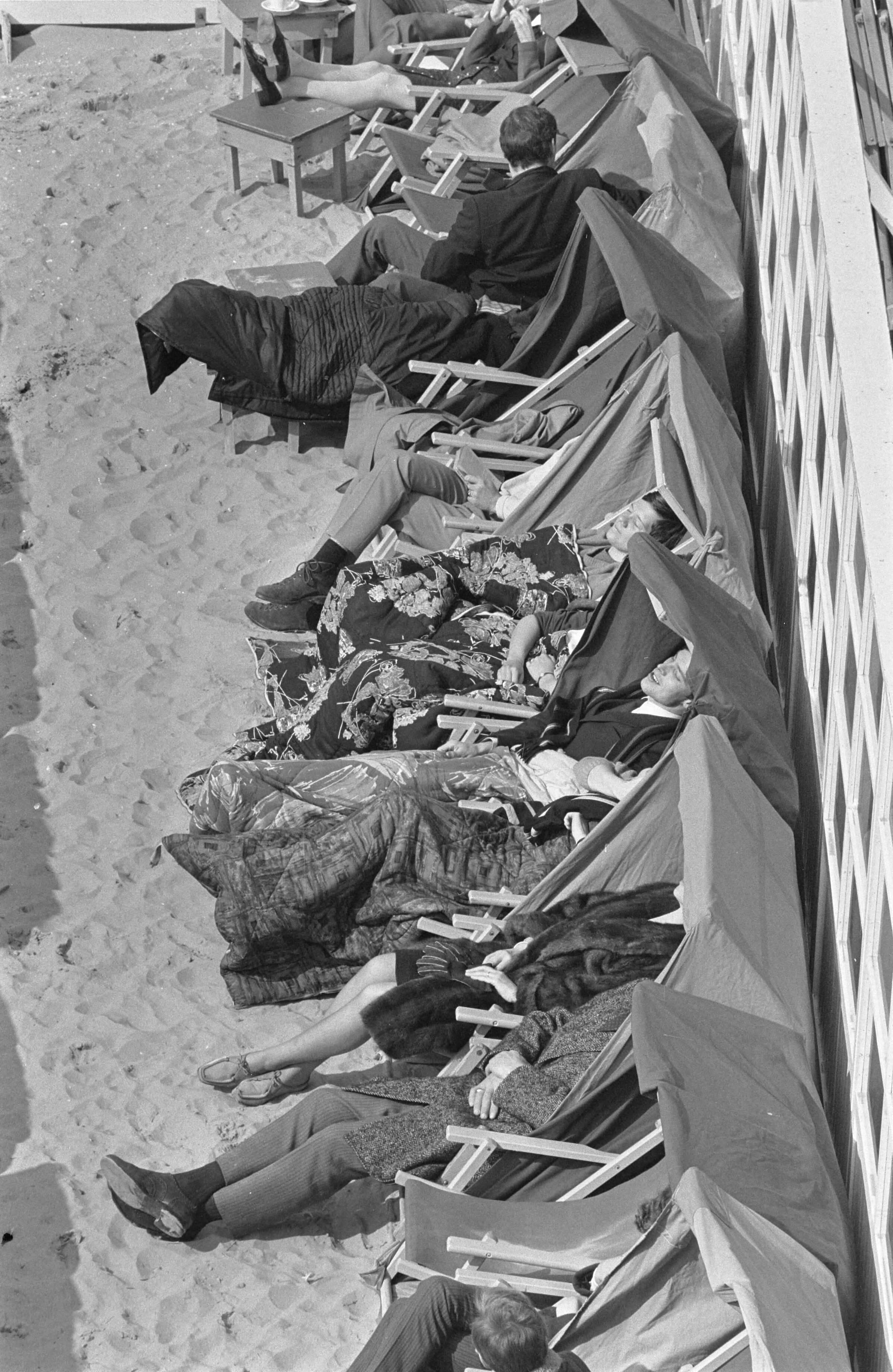 Fotocollectie Anefo — Eerste "stranddag" in Zandvoort zonnen onder dekens en jassen — Foto: Evers, Joost / Anefo. Licentie: Set B: Rechtenvrij / Publiek Domein. Bron: Nationaal Archief. http://hdl.handle.net/10648/ab631e34-d0b4-102d-bcf8-003048976d84