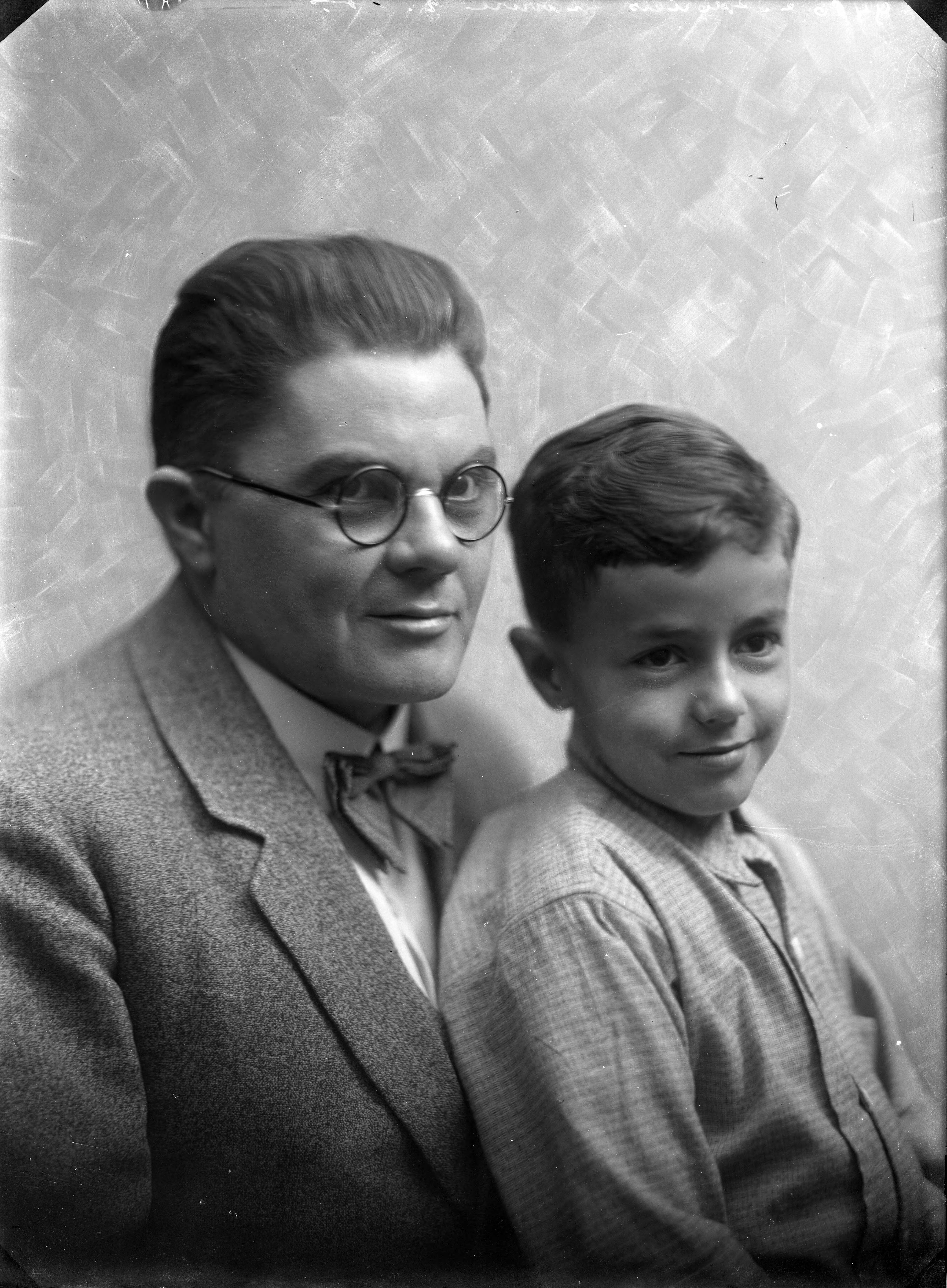 Portretten — Studio-opnames.Portretten. Portret van een vader in pak, met ronde bril en zijn zoontje. Haarlem, Nederland. 1918-1930. 9456 E. Gabriels gravure — Foto: Berg, Th.C.J. van den / Spaarnestad Photo (05887). Licentie: Set B: Rechtenvrij / Publiek Domein. Bron: Nationaal Archief. http://hdl.handle.net/10648/35429da7-c70d-a382-e063-6df0900a6686
