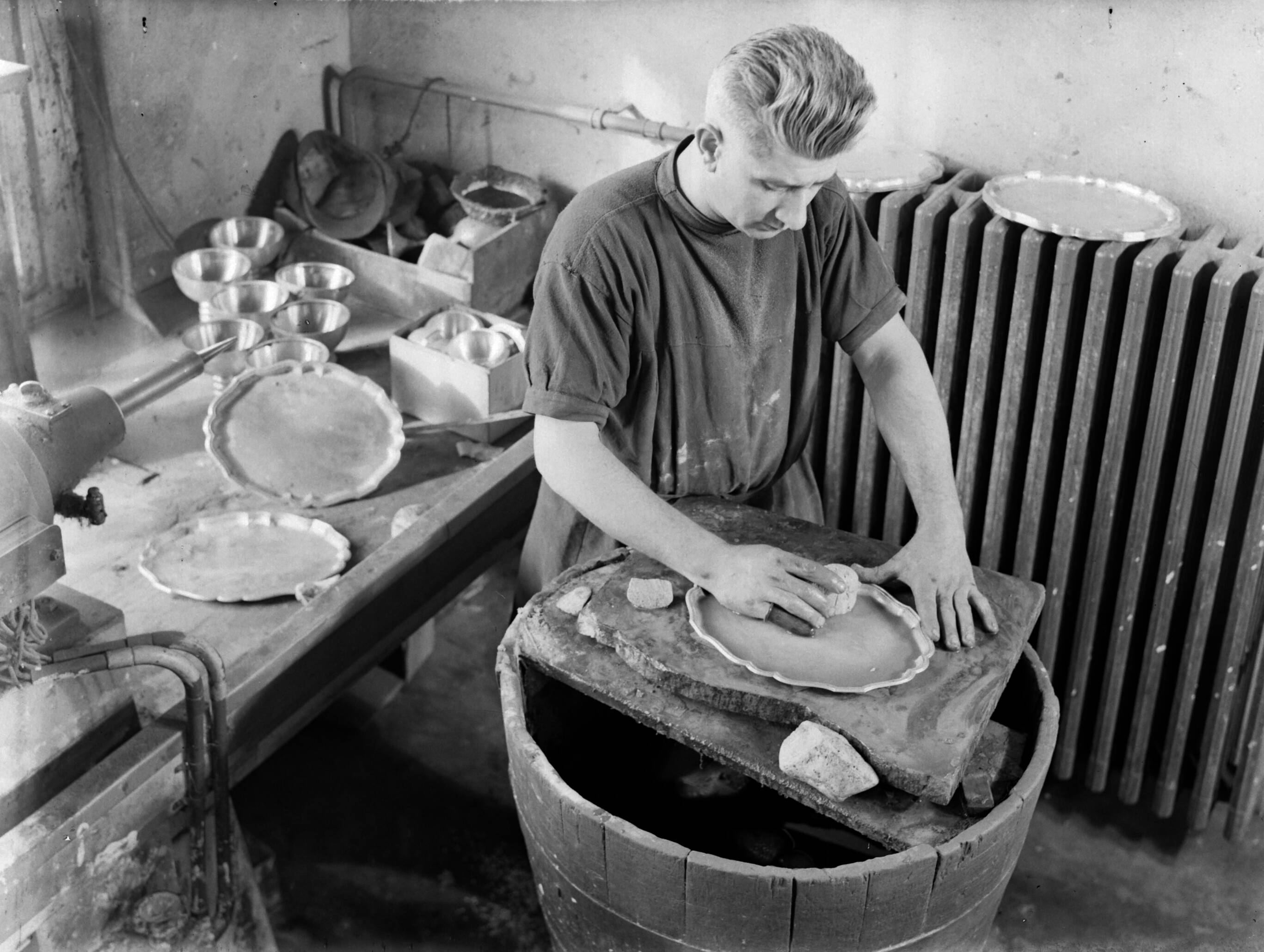 Productfoto's; zilverwerk — Met de hand nabewerken van zilveren producten bij de fa. Gerritsen & Van Kempen in Zeist — Foto: Poll, Willem van de. Licentie: Set B: Rechtenvrij / Publiek Domein. Bron: Nationaal Archief. http://hdl.handle.net/10648/ae9e41a0-d0b4-102d-bcf8-003048976d84
