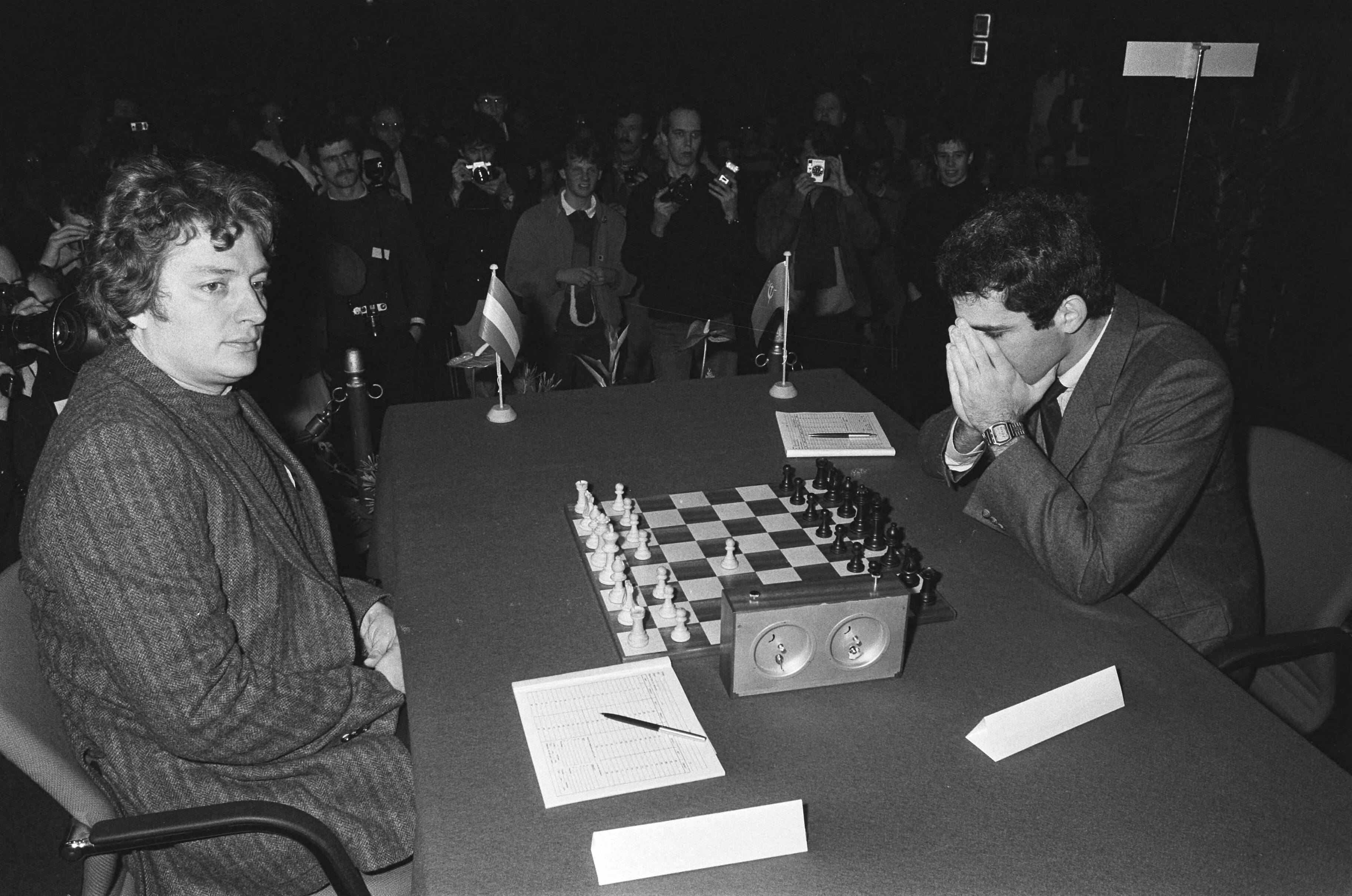 KRO Schaaktweekamp Timman - Kasparov 1985 — Kasparov (rechts) met zijn gezicht in zijn handen — Foto: Molendijk, Bart / Anefo. Licentie: Set B: Rechtenvrij / Publiek Domein. Bron: Nationaal Archief. http://hdl.handle.net/10648/ad4e1c8a-d0b4-102d-bcf8-003048976d84