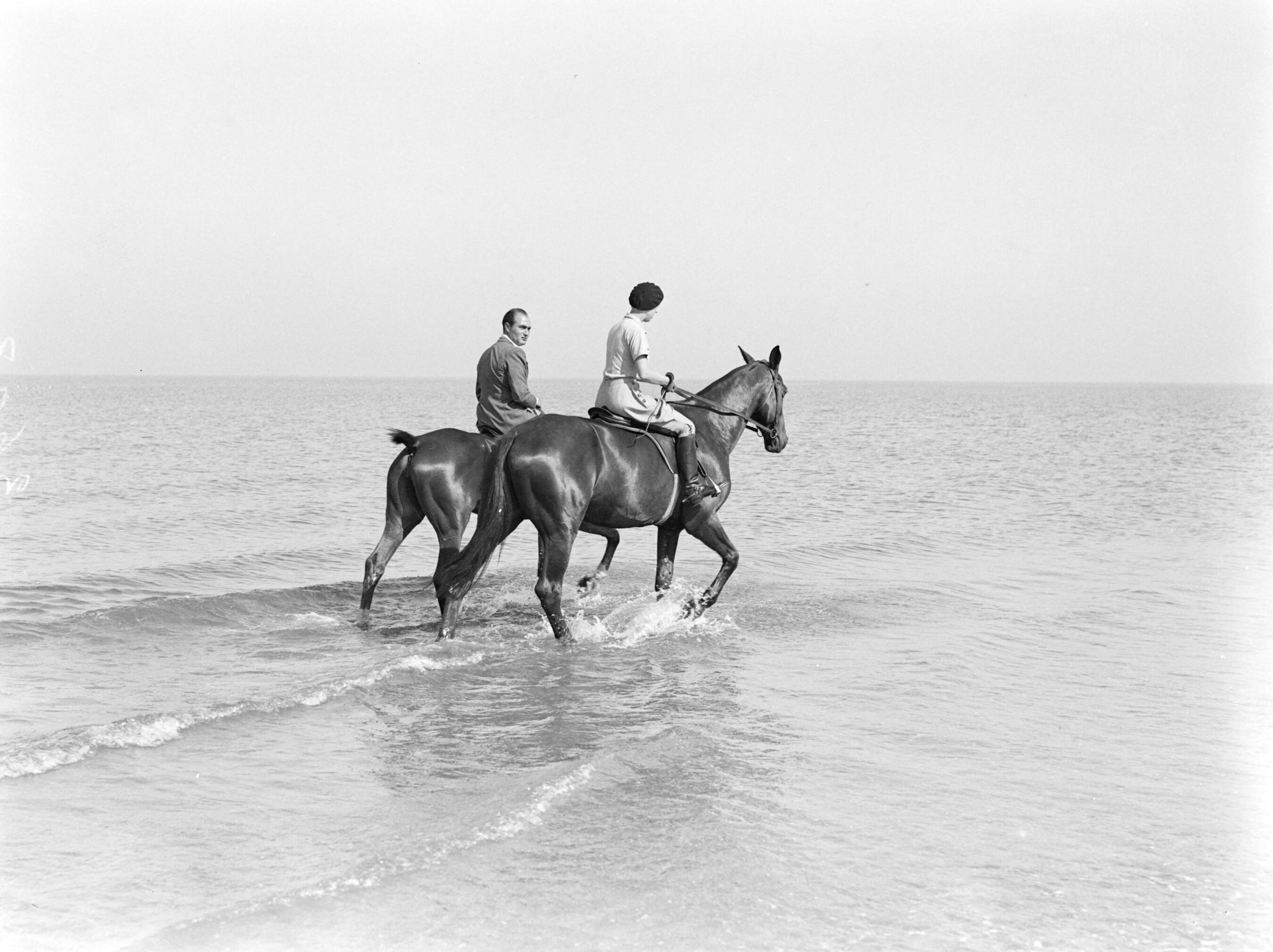 Scheveningen. — Een man (Farrar?) en een vrouw (Yvonne?) te paard aan het Scheveningse strand — Foto: Poll, Willem van de. Licentie: Set B: Rechtenvrij / Publiek Domein. Bron: Nationaal Archief. http://hdl.handle.net/10648/ae9b1ca0-d0b4-102d-bcf8-003048976d84