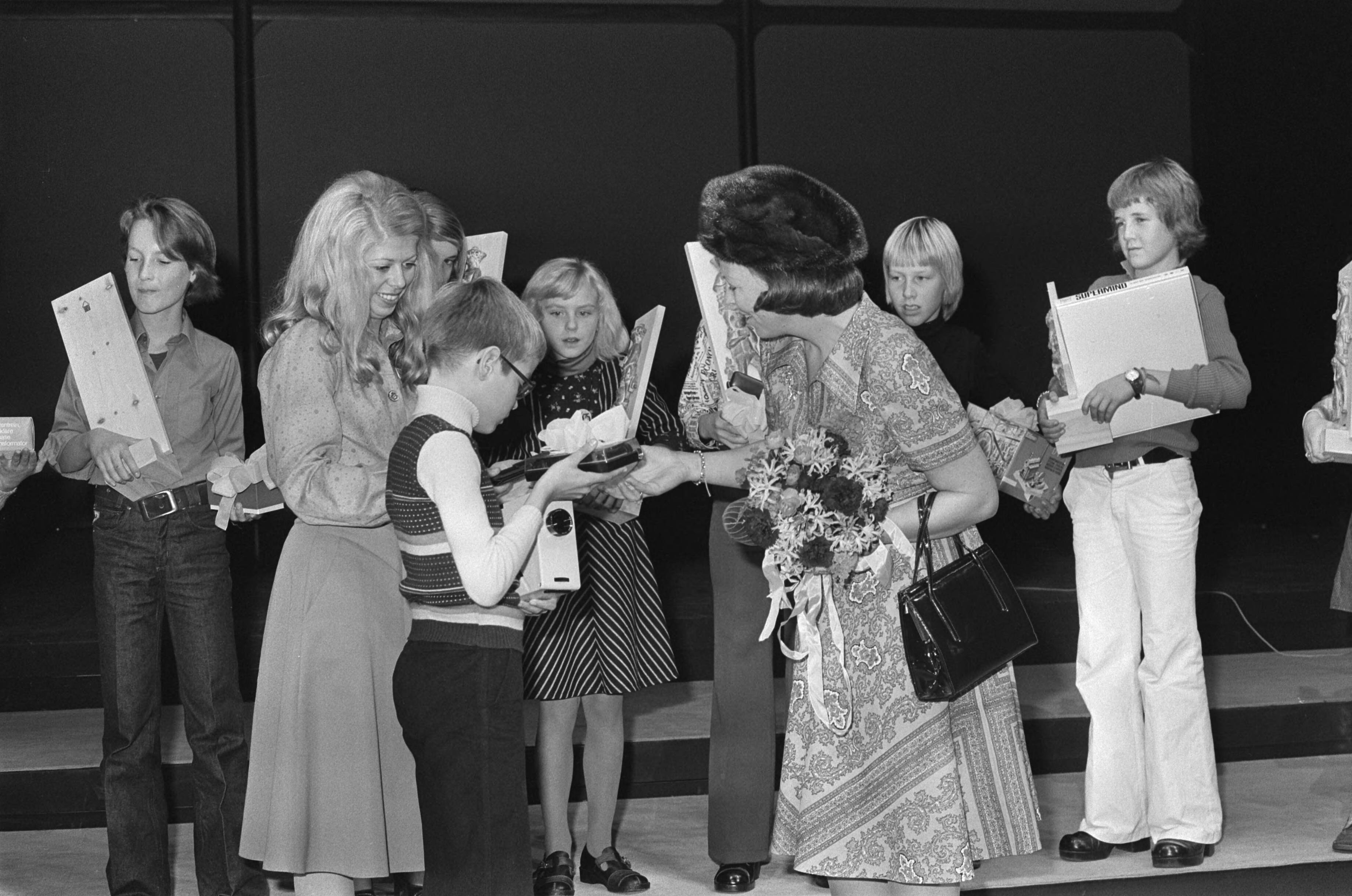 Fotocollectie Anefo — Prinses Beatrix bij kleurendiawedstrijd voor schookinderen in Den Haag ; Prinses Beatrix reikt prijzen uit — Foto: Croes, Rob C. / Anefo. Licentie: Set B: Rechtenvrij / Publiek Domein. Bron: Nationaal Archief. http://hdl.handle.net/10648/ac760192-d0b4-102d-bcf8-003048976d84