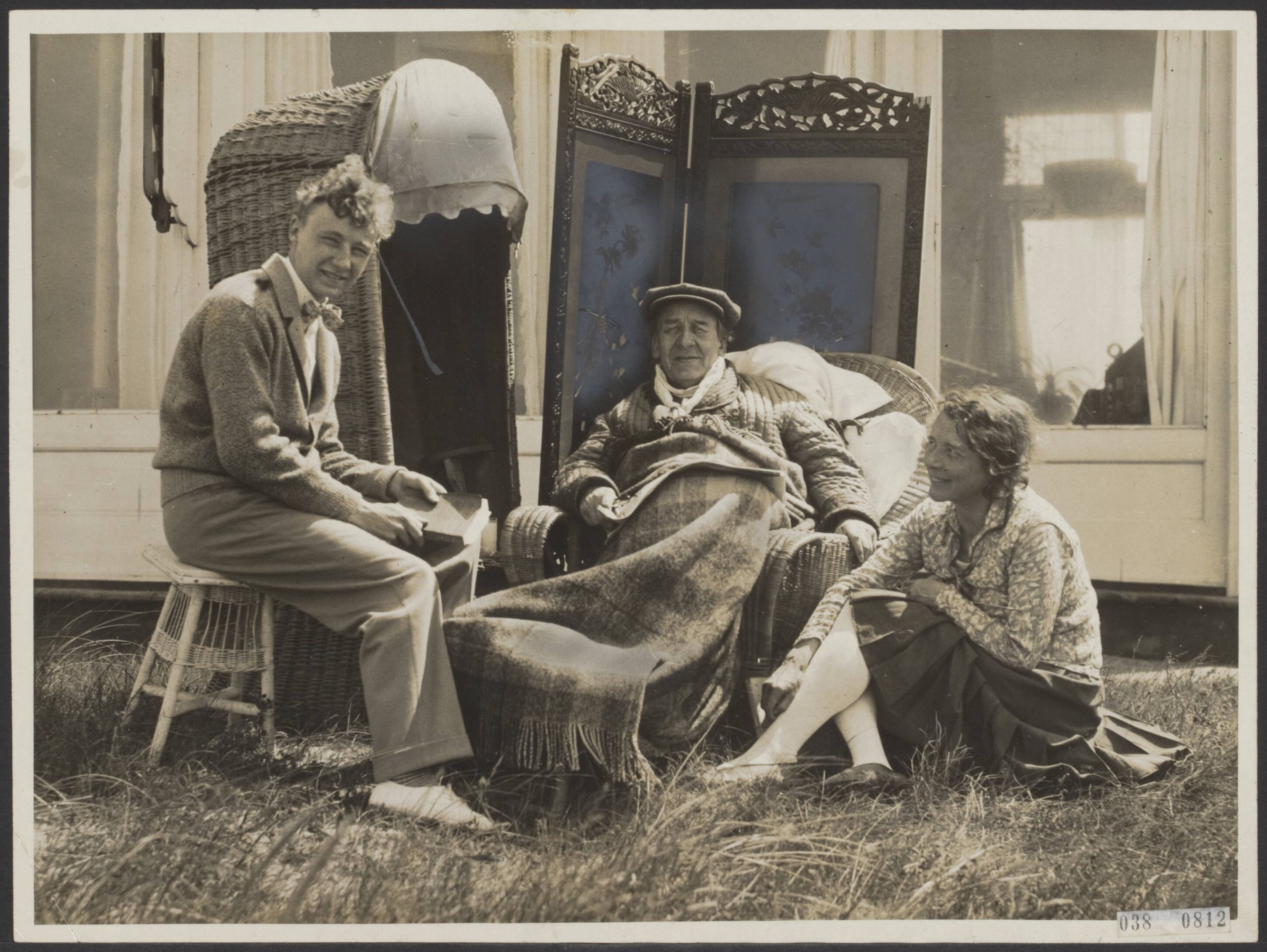 Fotocollectie Elsevier Binnenland — Dr. Willem Royaards. Onze toneelnestor is in weer zoverre hersteld dat hij enige uren in de tuin van zijn villa te Zandvoort kan doorbrengen. Vlnr. Royaards jr., dr. Willem Royaards en zijn vrouw (Jacoba Philippina Sandberg) genietend van het heerlijke zonnetje — Foto: N.V. Polygoon. Licentie: Set B: Rechtenvrij / Publiek Domein. Bron: Nationaal Archief. http://hdl.handle.net/10648/adf28766-d0b4-102d-bcf8-003048976d84