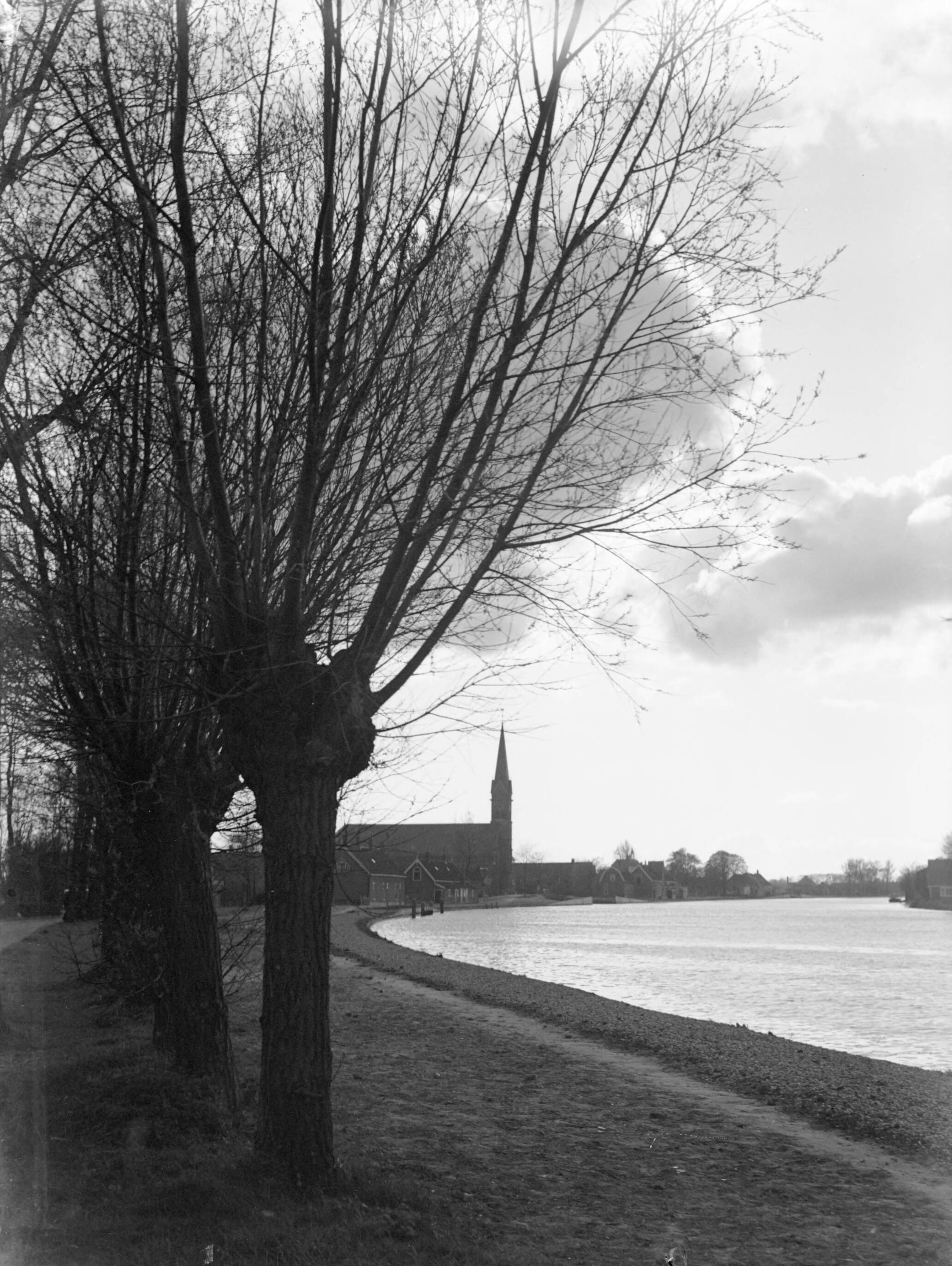 Reportage boerderij — Knotwilgen langs de Oude Rijn nabij Hazerswoude, met een kerk op de achtergrond — Foto: Poll, Willem van de. Licentie: Set B: Rechtenvrij / Publiek Domein. Bron: Nationaal Archief. http://hdl.handle.net/10648/ae99ab0e-d0b4-102d-bcf8-003048976d84